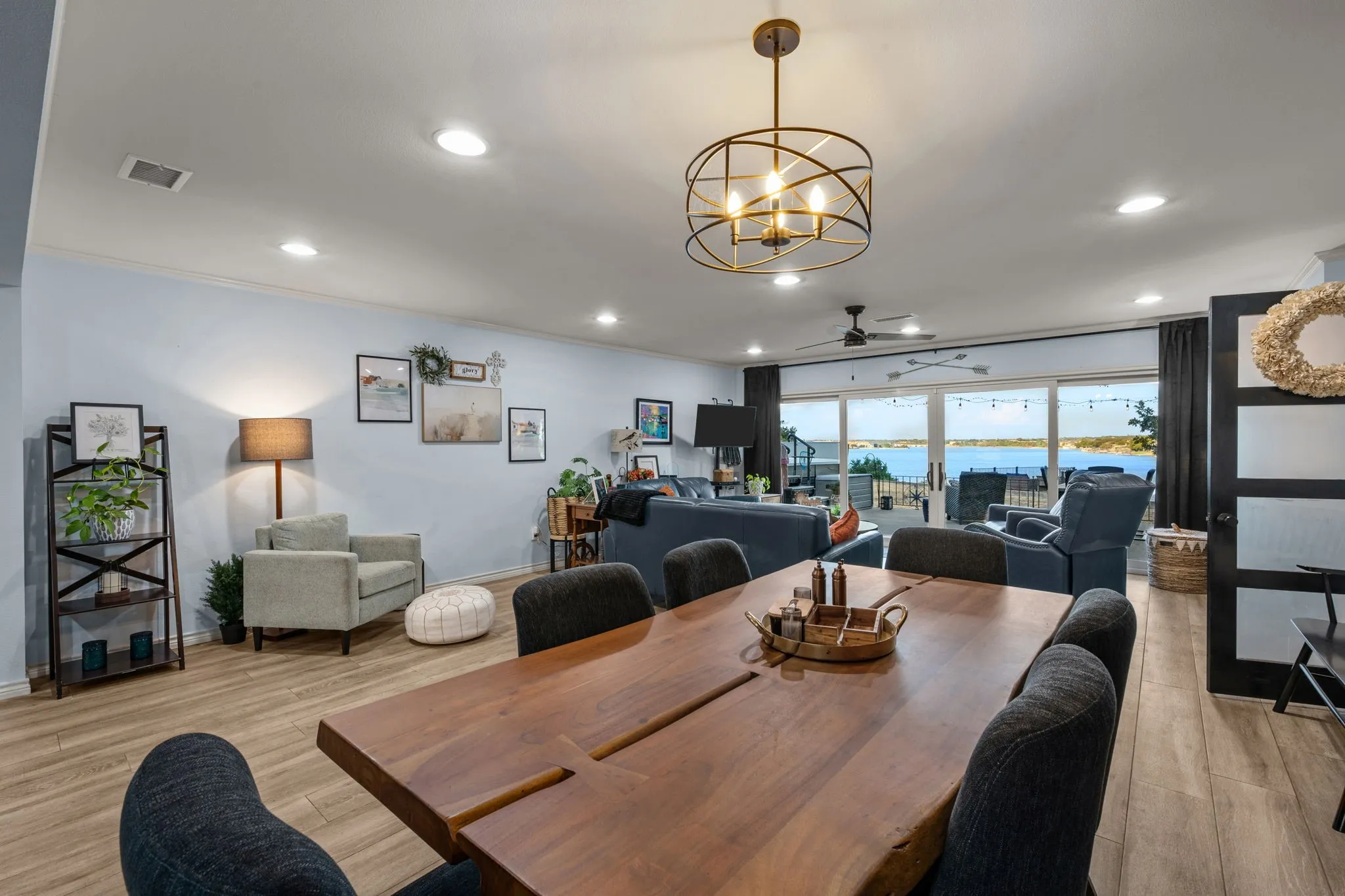 Open-concept living area featuring wood-finish flooring, recessed lighting, and a modern chandelier
