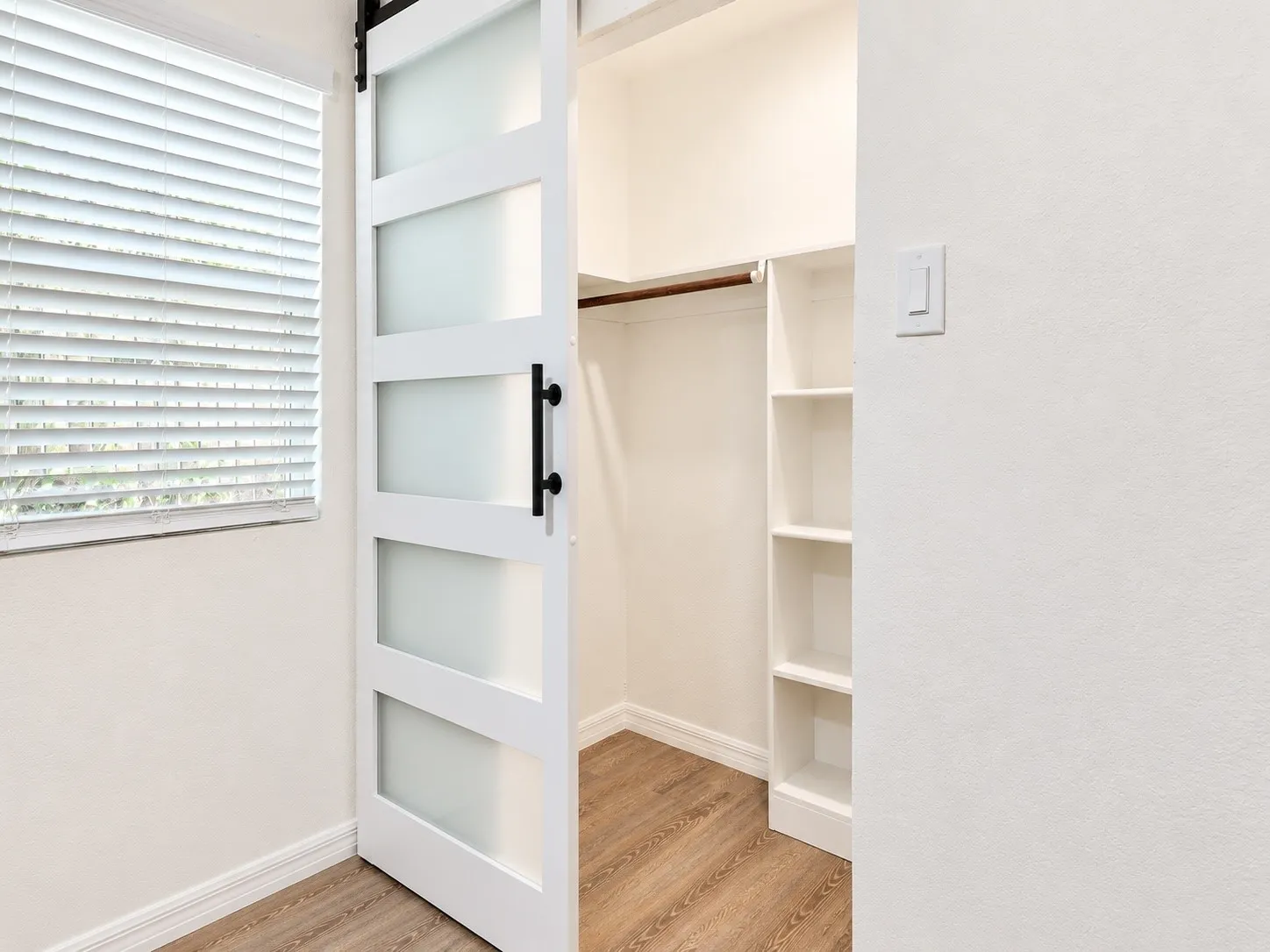 Primary closet entrance with sliding barn-style door and built-in storage.