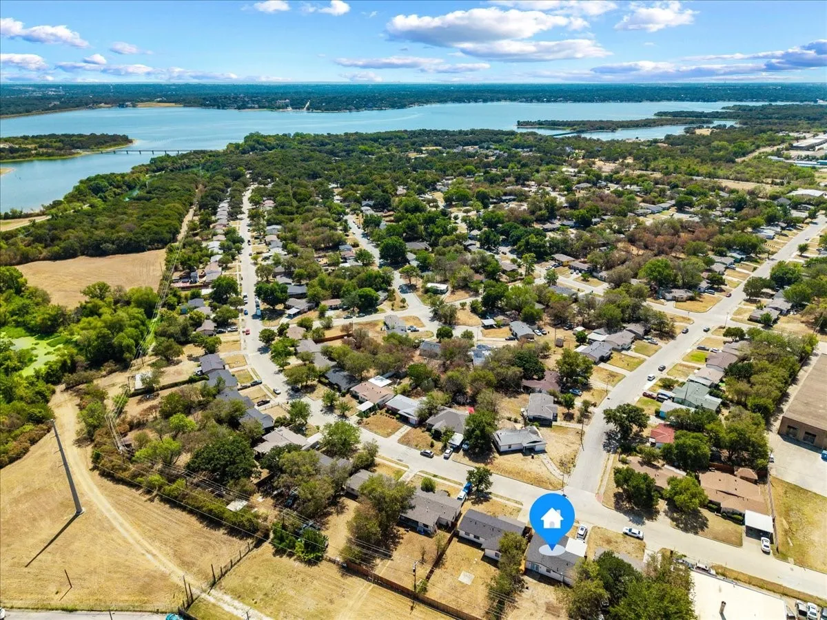 Elevated aerial showing the surrounding residential neighborhood and nearby waterfront.