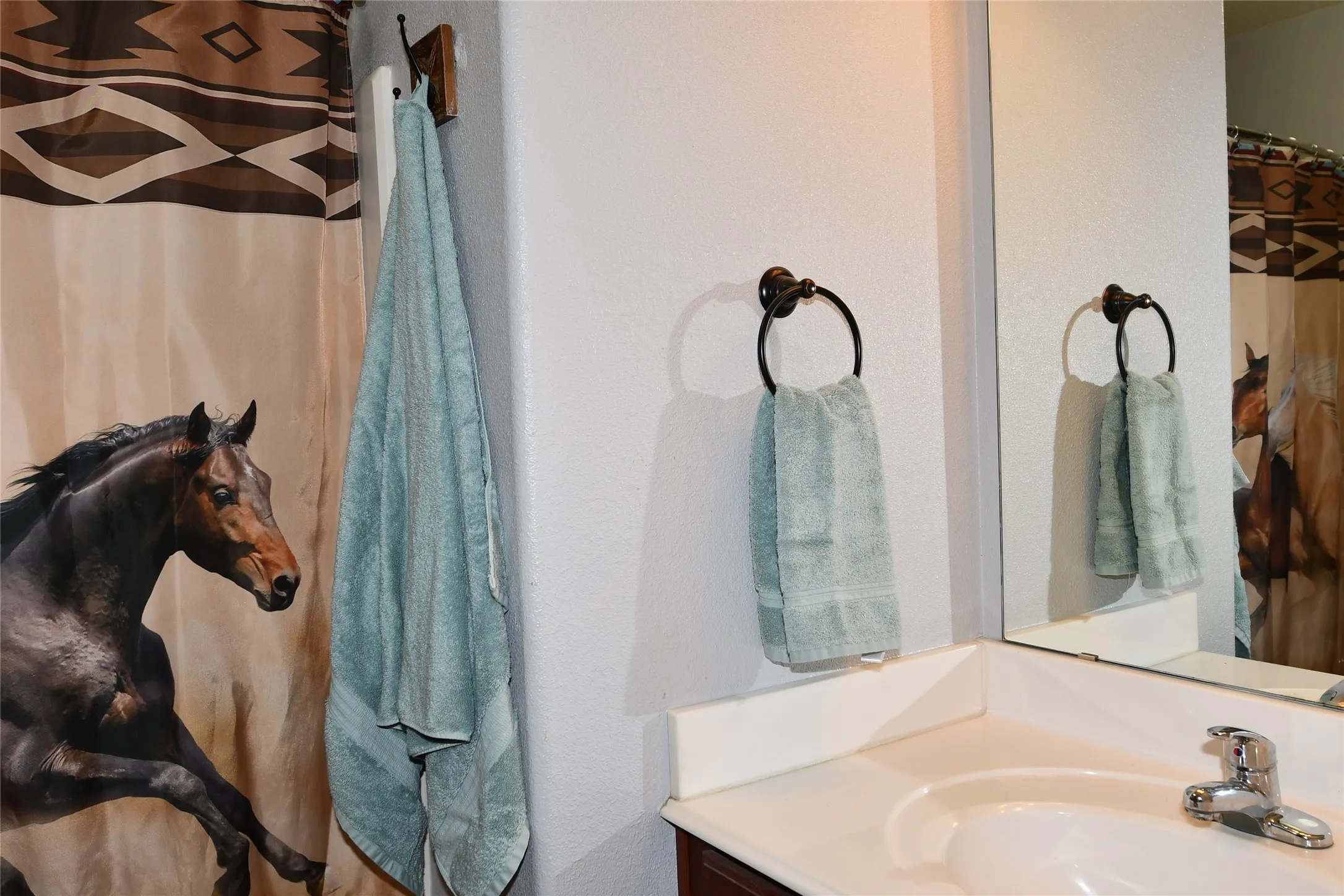 Vanity with an integrated sink, polished chrome faucet, and a wall-mounted mirror