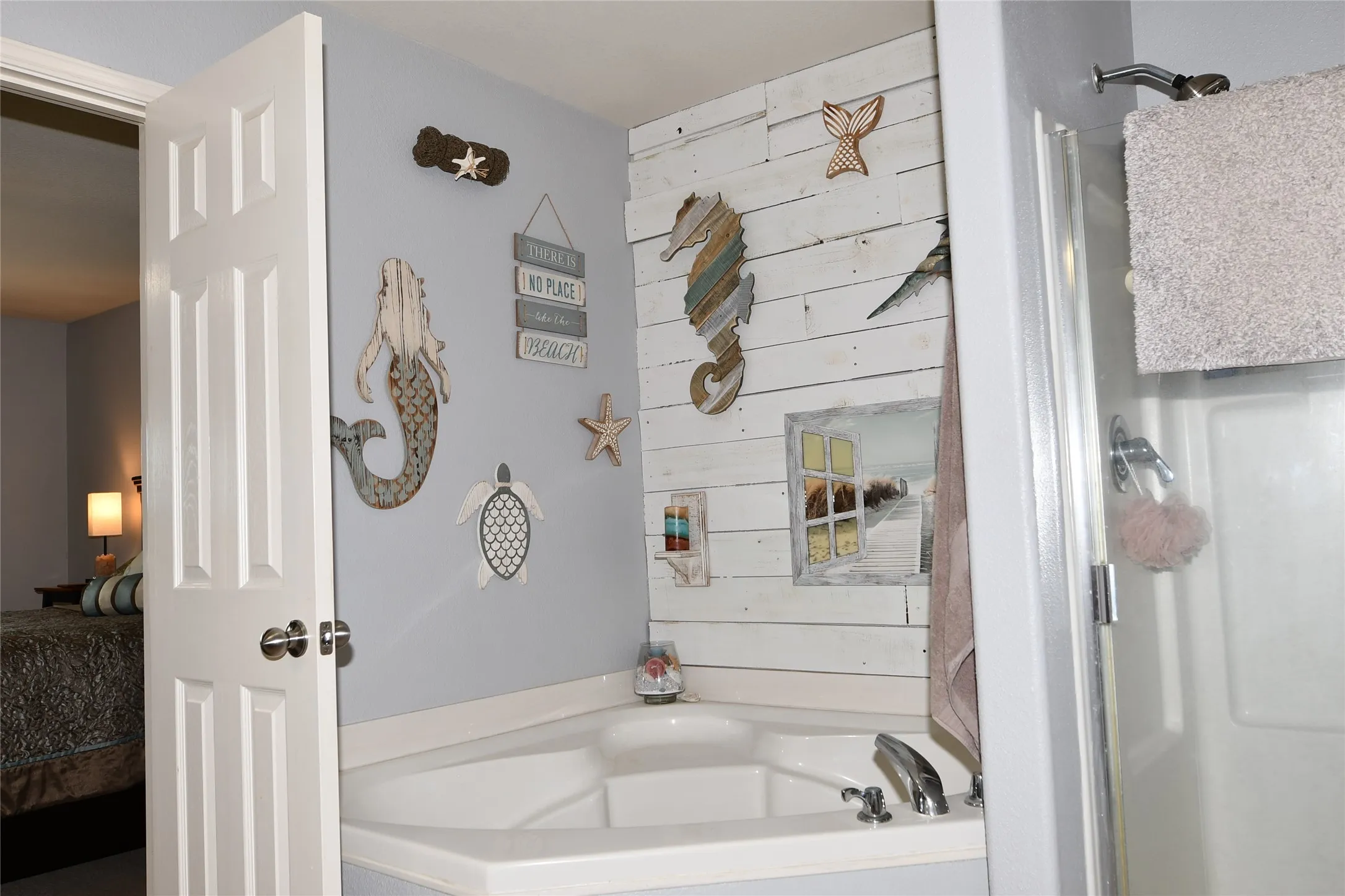 Corner soaking tub with polished chrome fixtures and an adjacent walk-in shower