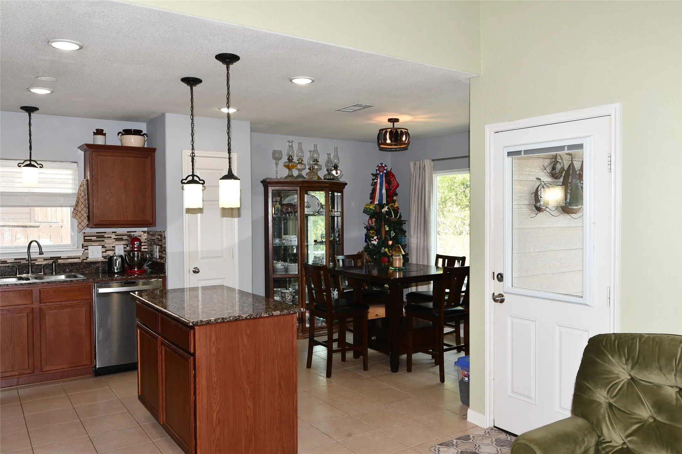 Kitchen featuring a center island with a granite countertop, wood cabinetry, stainless steel appliances, and recessed lighting