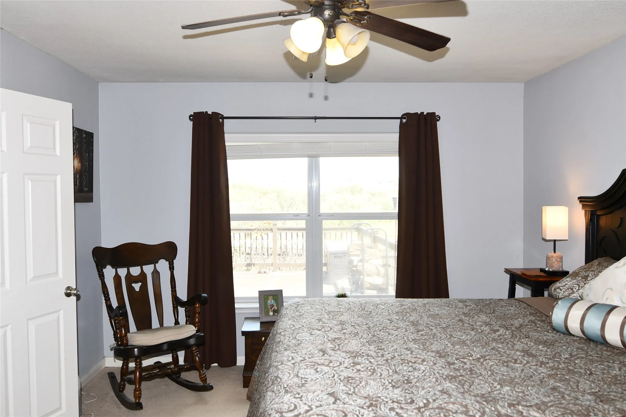 Ceiling fan with integrated lighting, window with outdoor scenery, recessed window, and white interior door