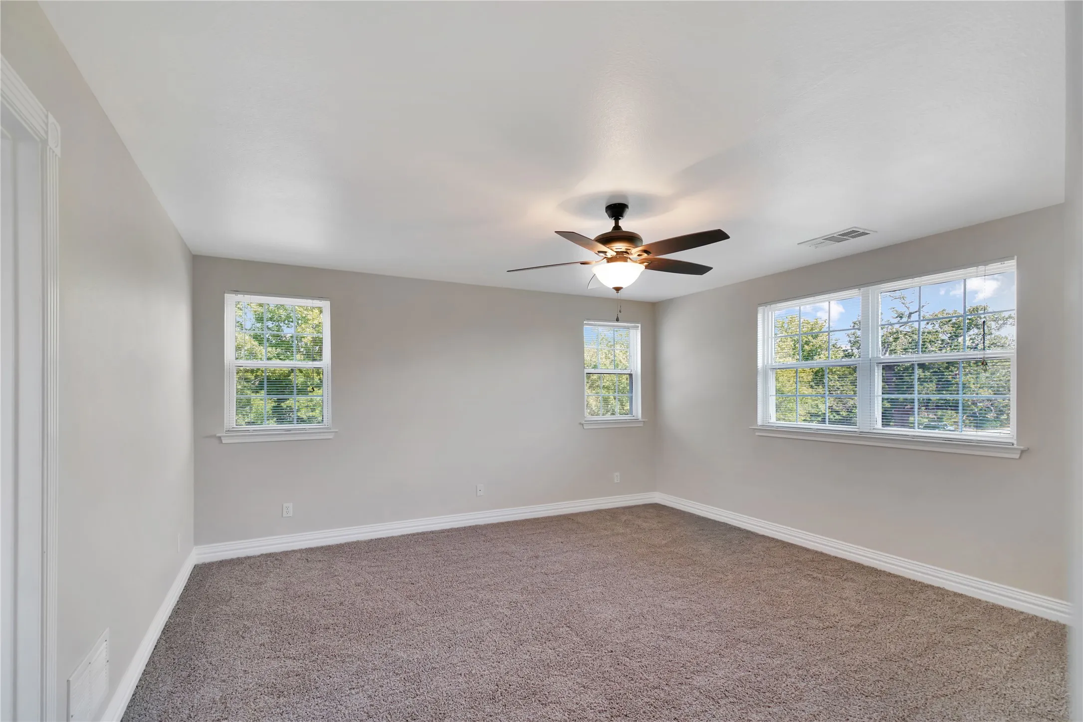 Spacious room featuring carpet flooring and light-toned walls