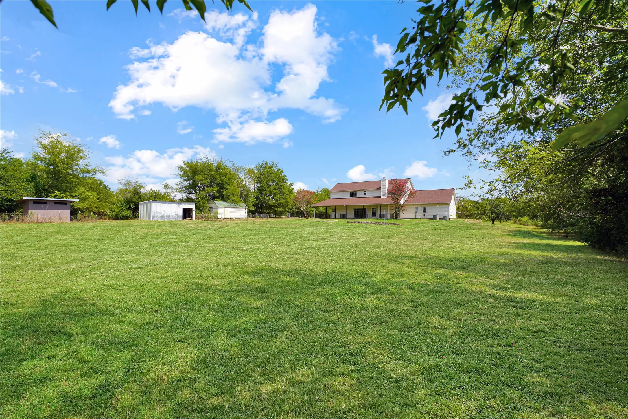 Expansive grassy grounds with a detached shed and a secondary outbuilding