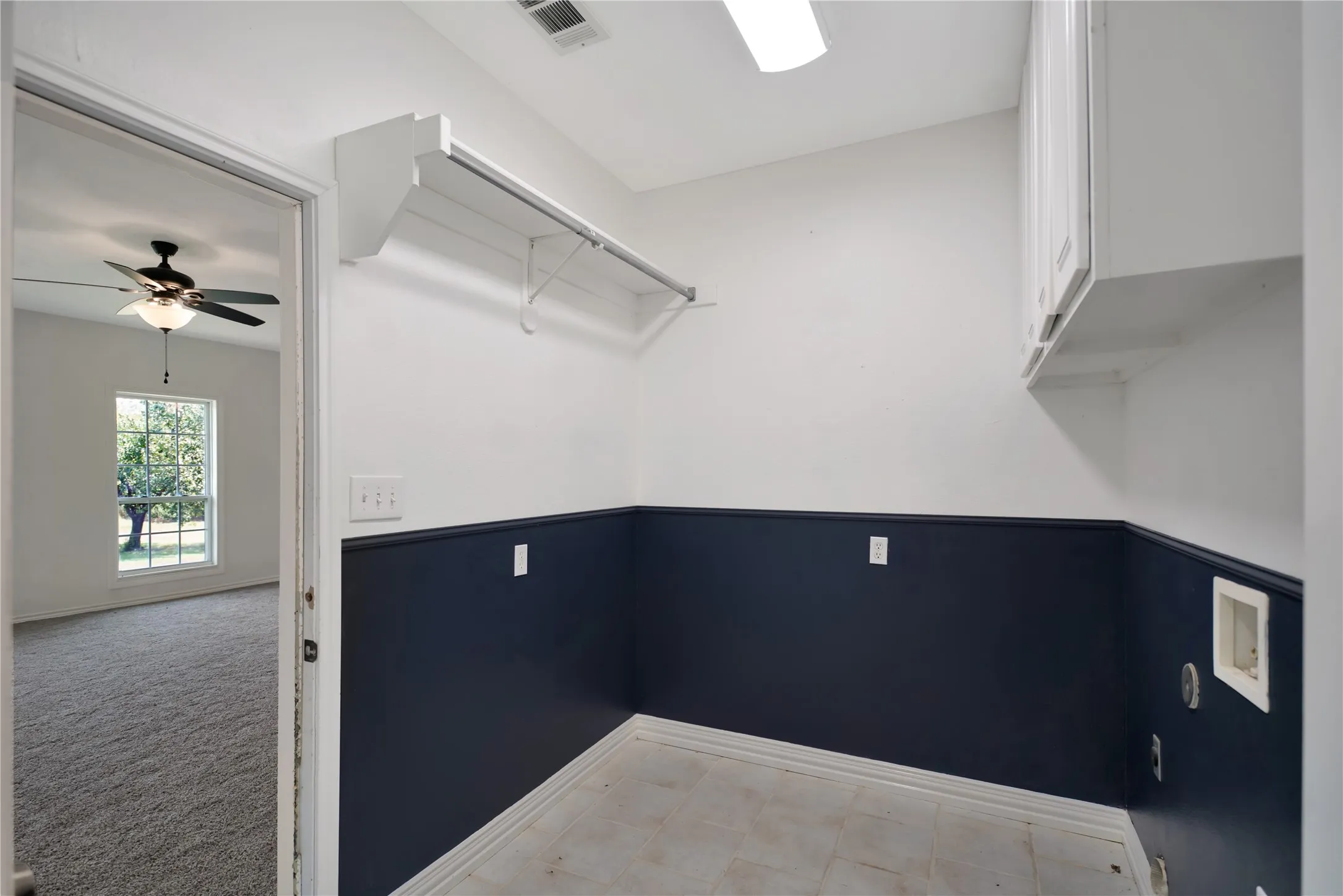 Utility room featuring dark navy wainscoting, white upper walls, recessed ceiling lighting, and a ceiling-mounted HVAC unit