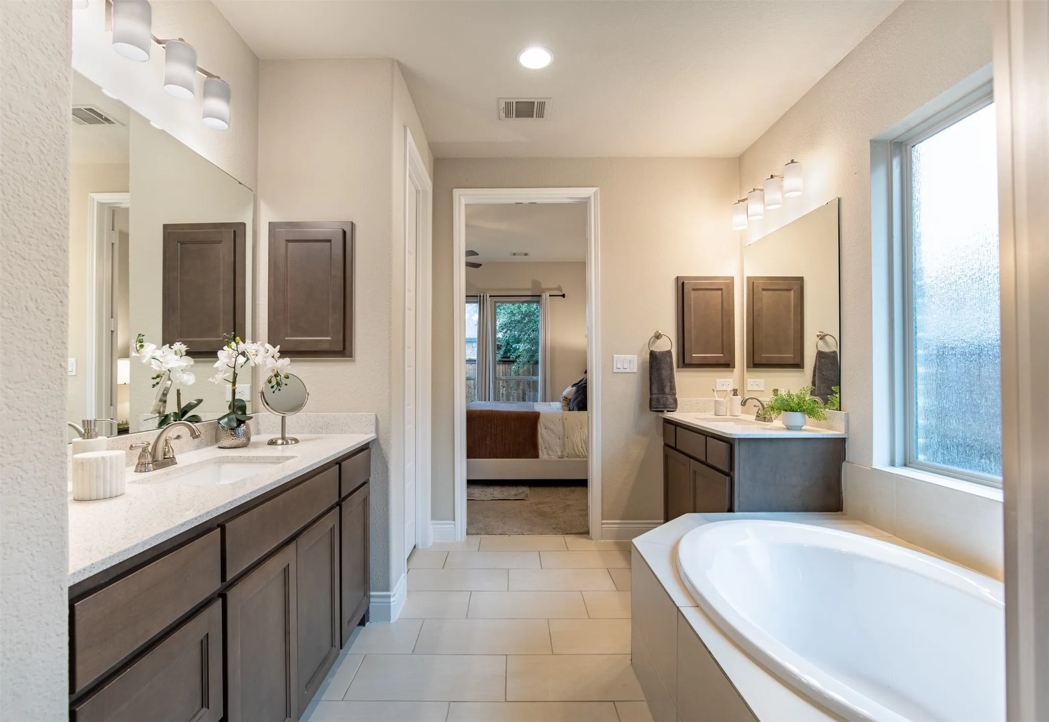 Dual vanities with integrated sinks, light-toned countertops, and dark wood-finish cabinetry