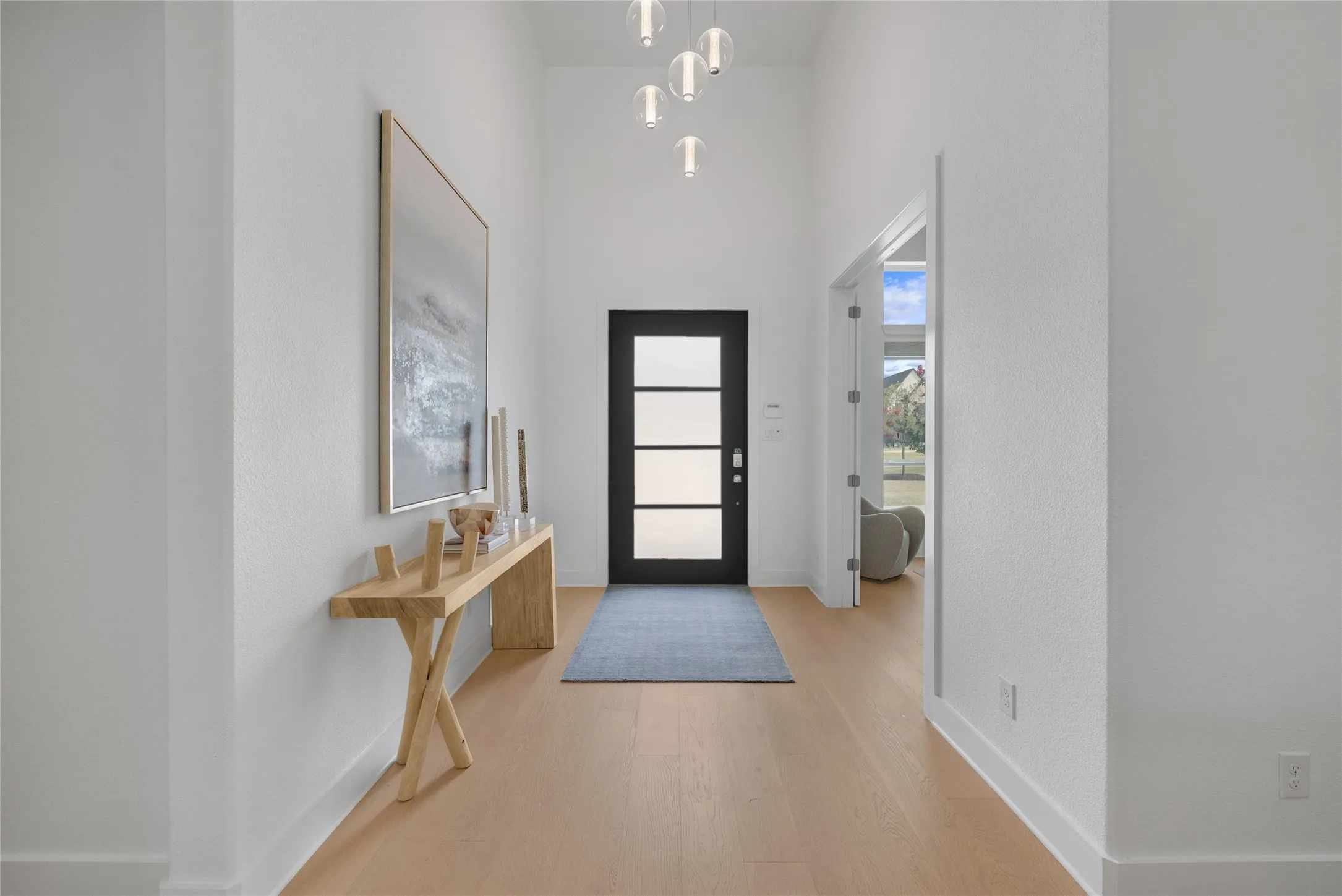 Light and Open Entry with modern front door and elegant lighting fixtures