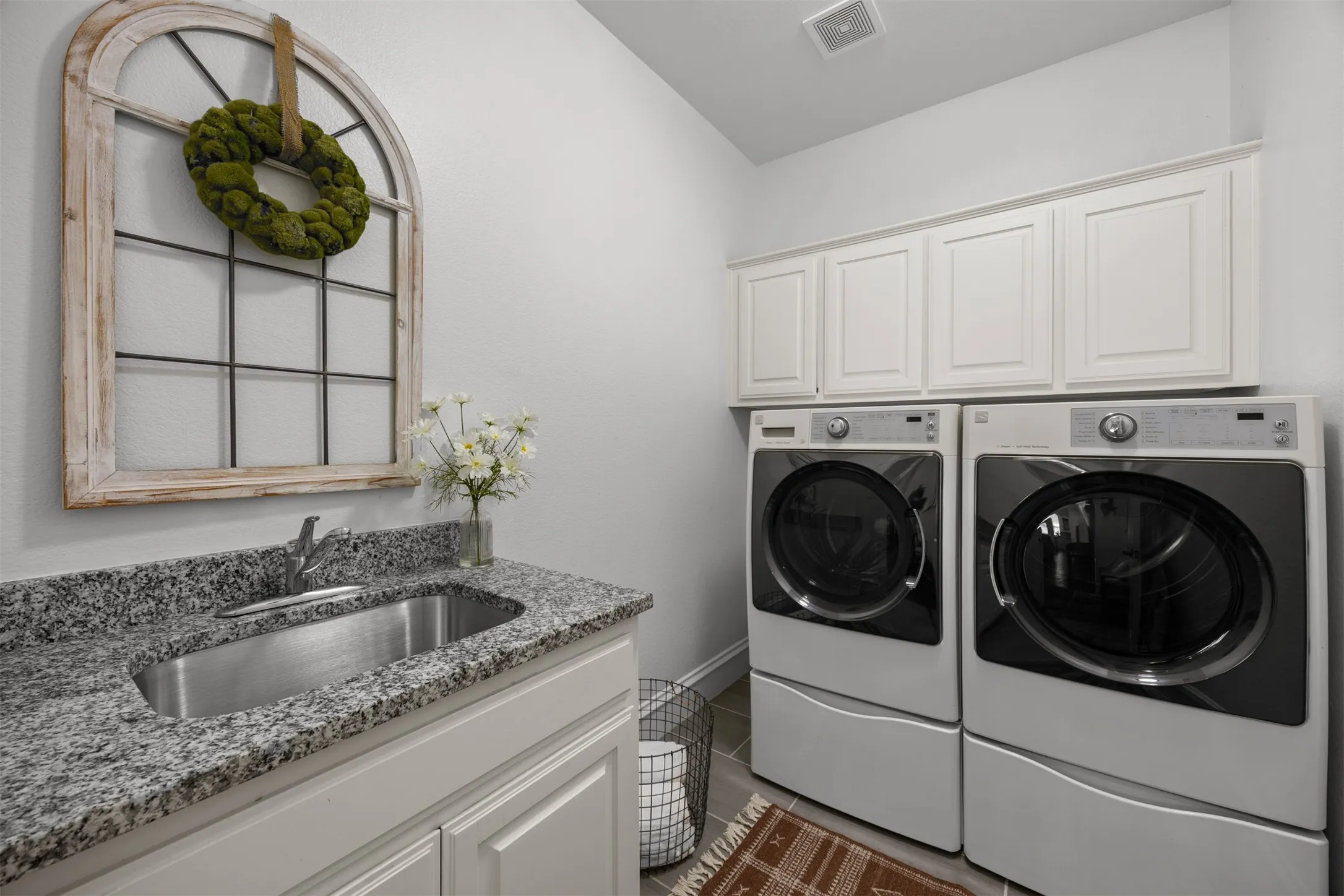 So nice to have a utility sink and plenty of cabinetry in your laundry room!