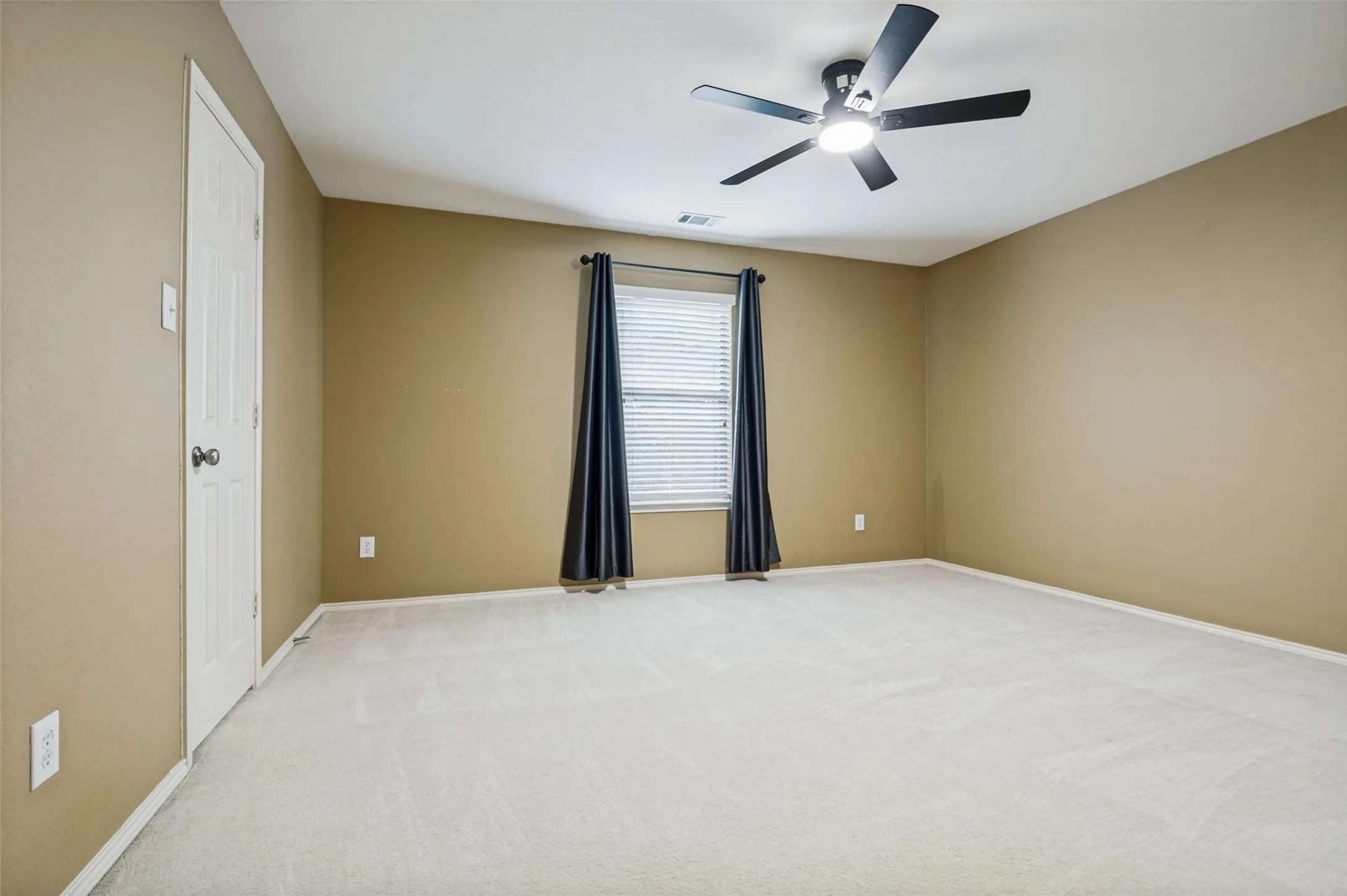 Room featuring wall-to-wall carpeting, a multi-pane window with blinds, and a ceiling fan with integrated lighting