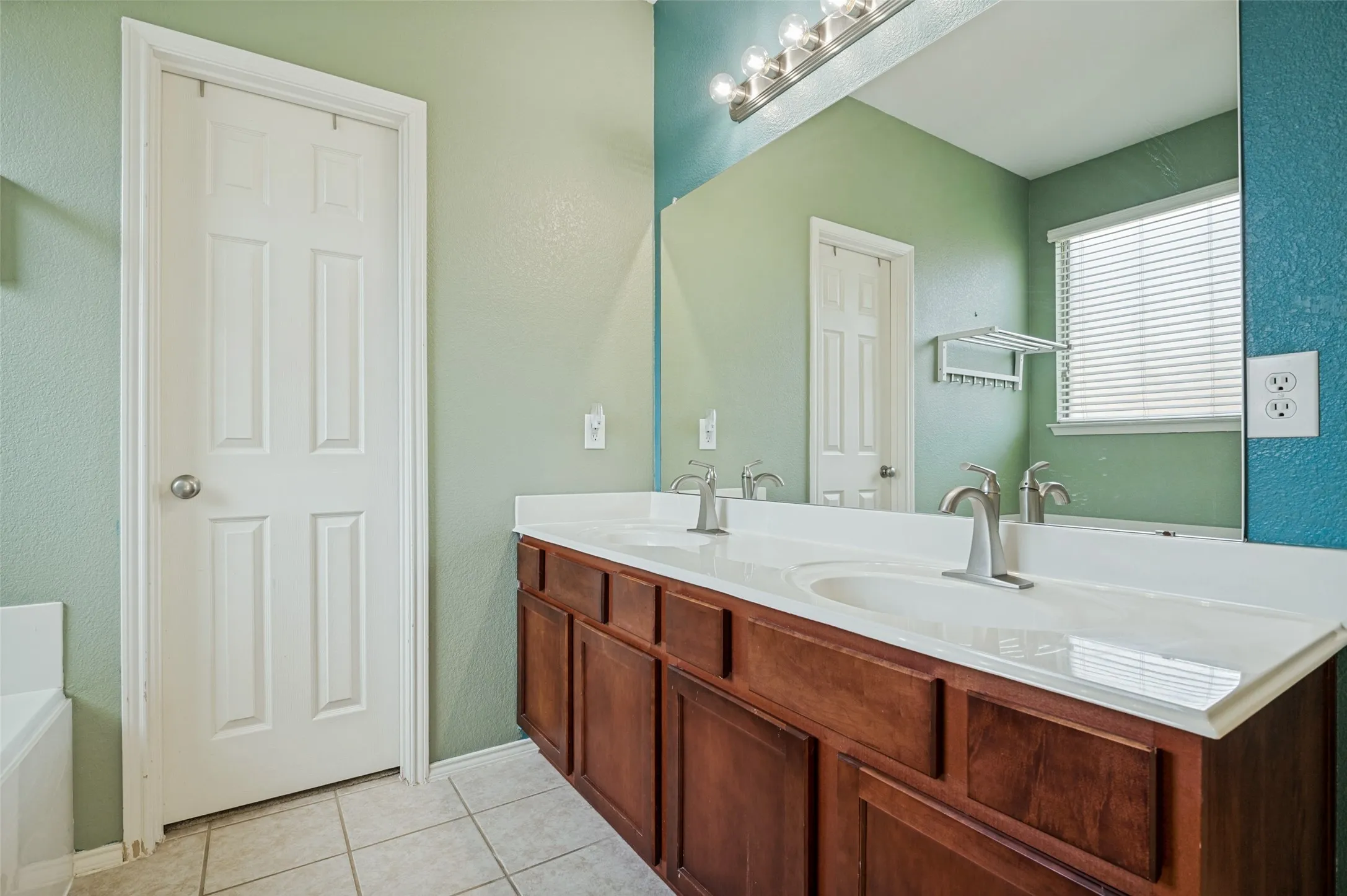 Dual vanity with under-sink cabinetry, integrated white sinks, and brushed nickel faucets