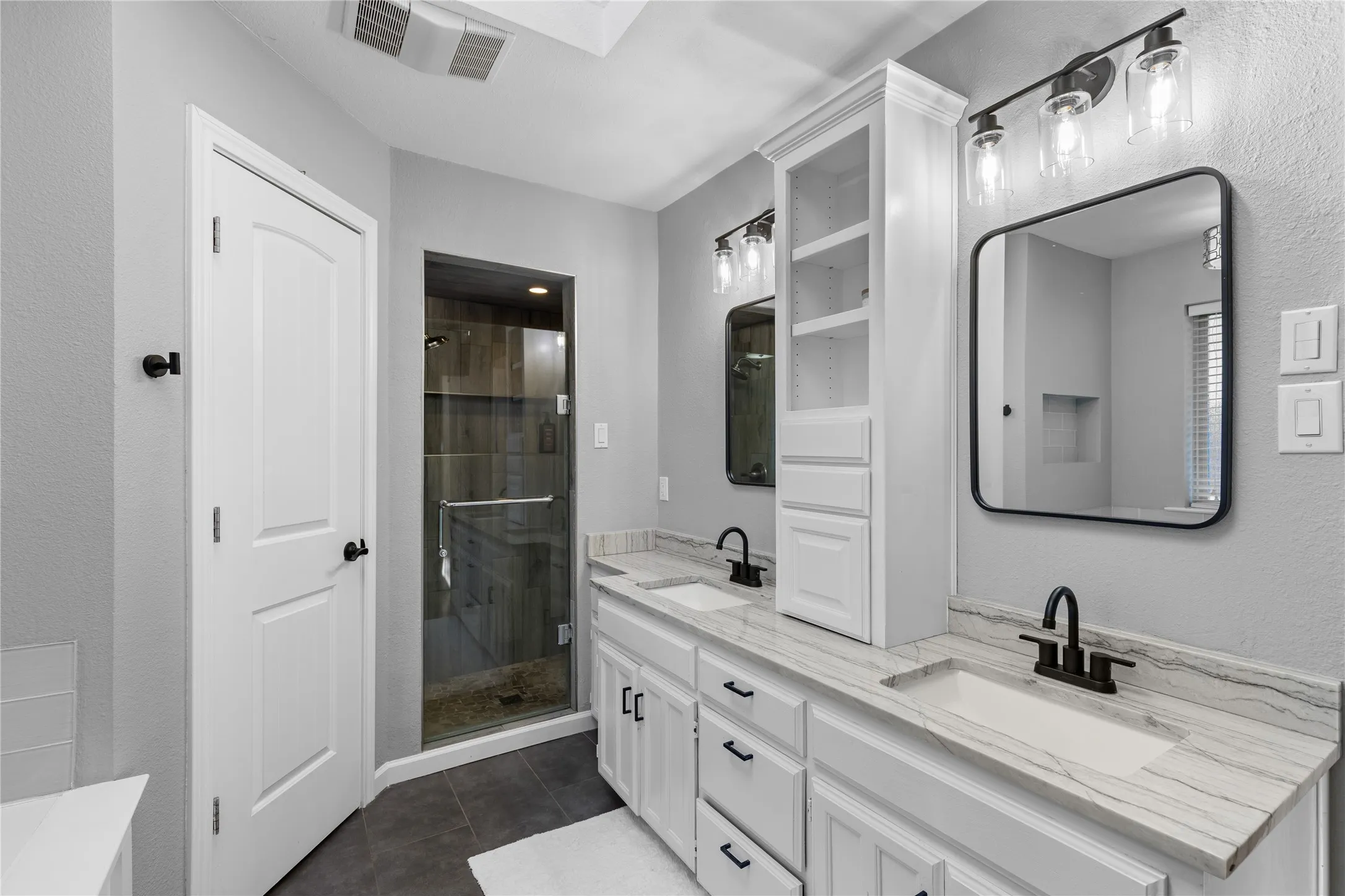 Dual vanity with undermount sinks, stone countertops, and matte black fixtures