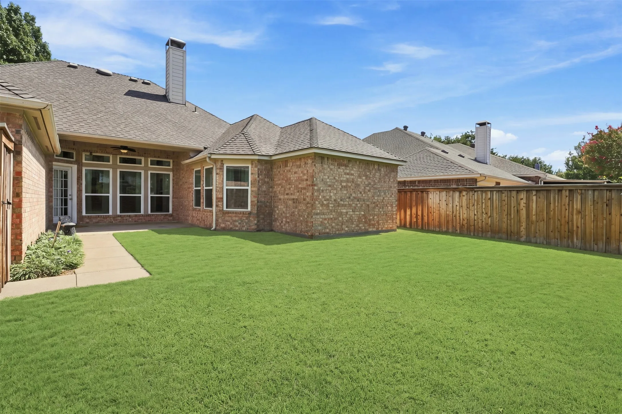 Large backyard with St Augustine grass and landscaping.