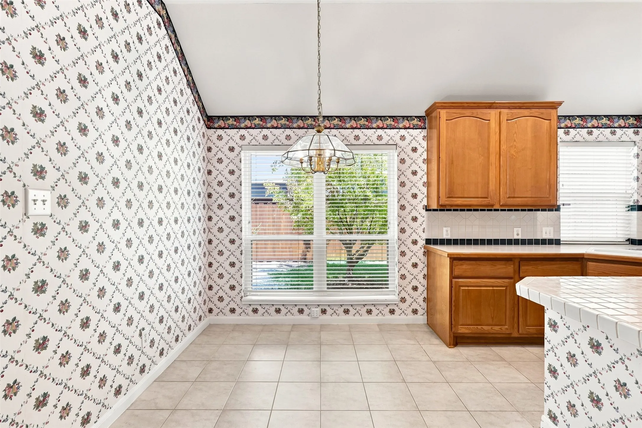 Dining area with a large window and light fixture to define the space.