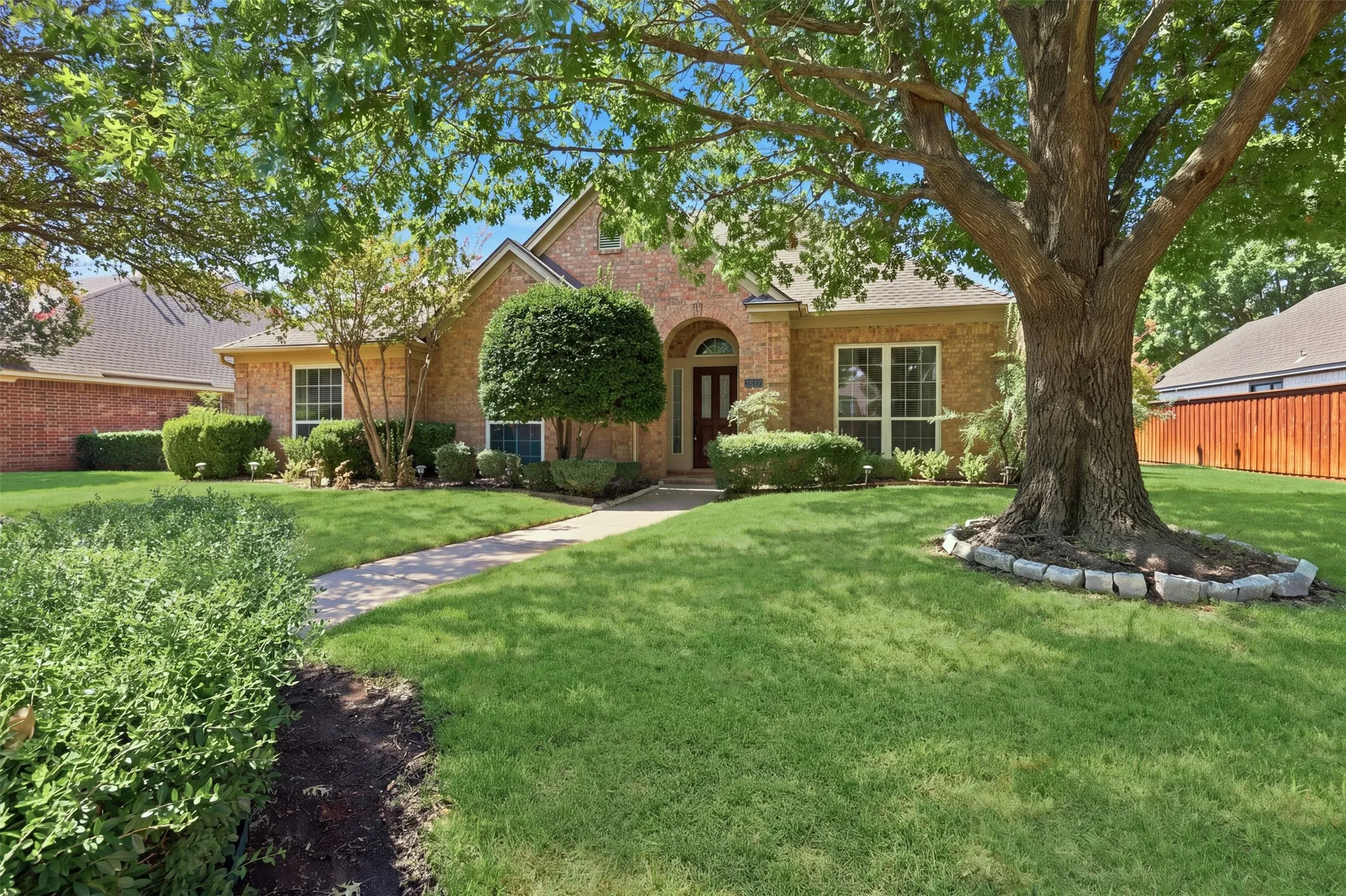 Lush St Augustine grass and landscaped yard with mature trees welcome you home at the end of a long day!