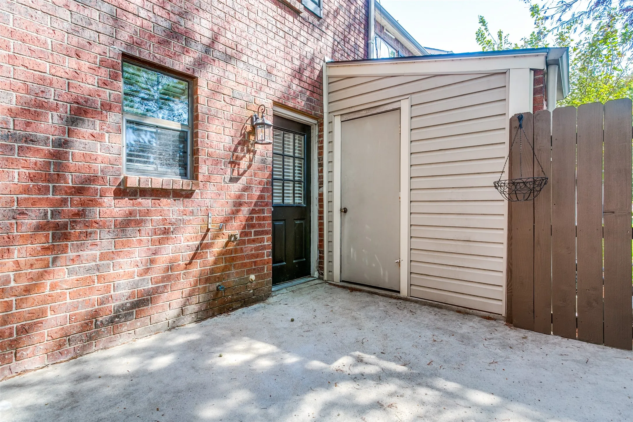 Back private patio with extra storage and gate to greenbelt