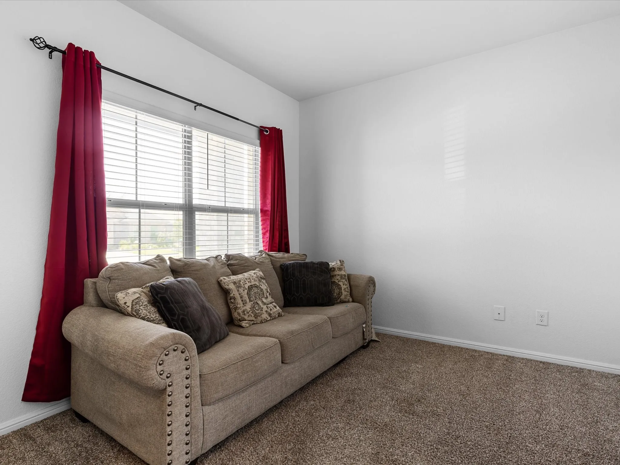 Carpeted flooring, white walls, and a window with blinds