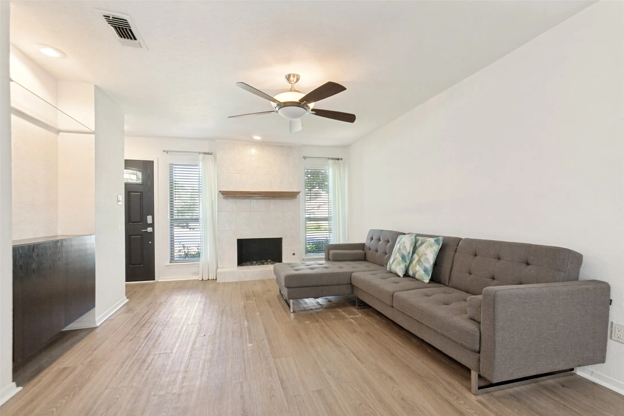 Wood-finish flooring, recessed lighting, and a ceiling fan with light