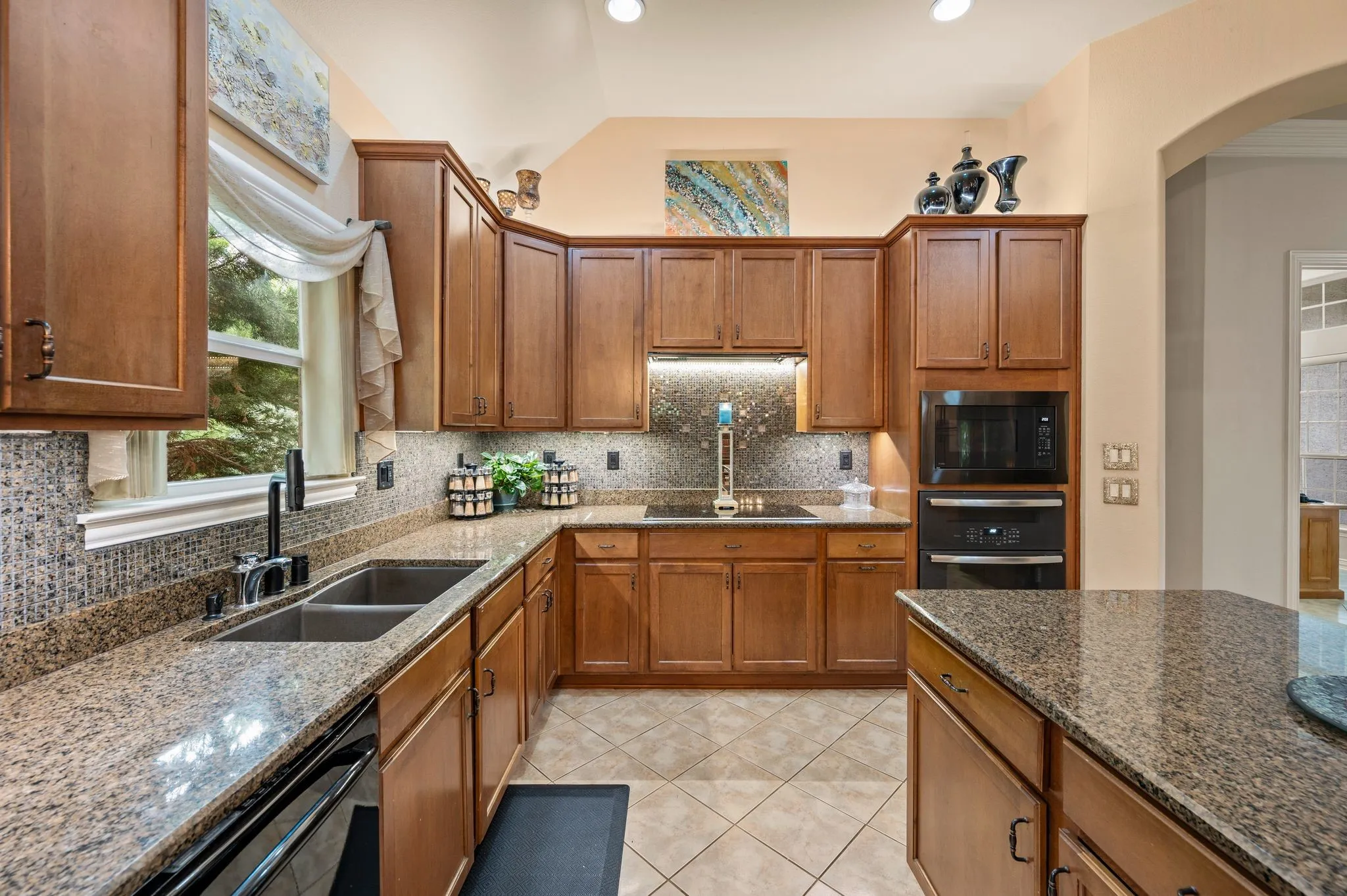 Kitchen featuring wood cabinetry, stone countertops, a tile backsplash, recessed lighting, and a built-in oven and microwave