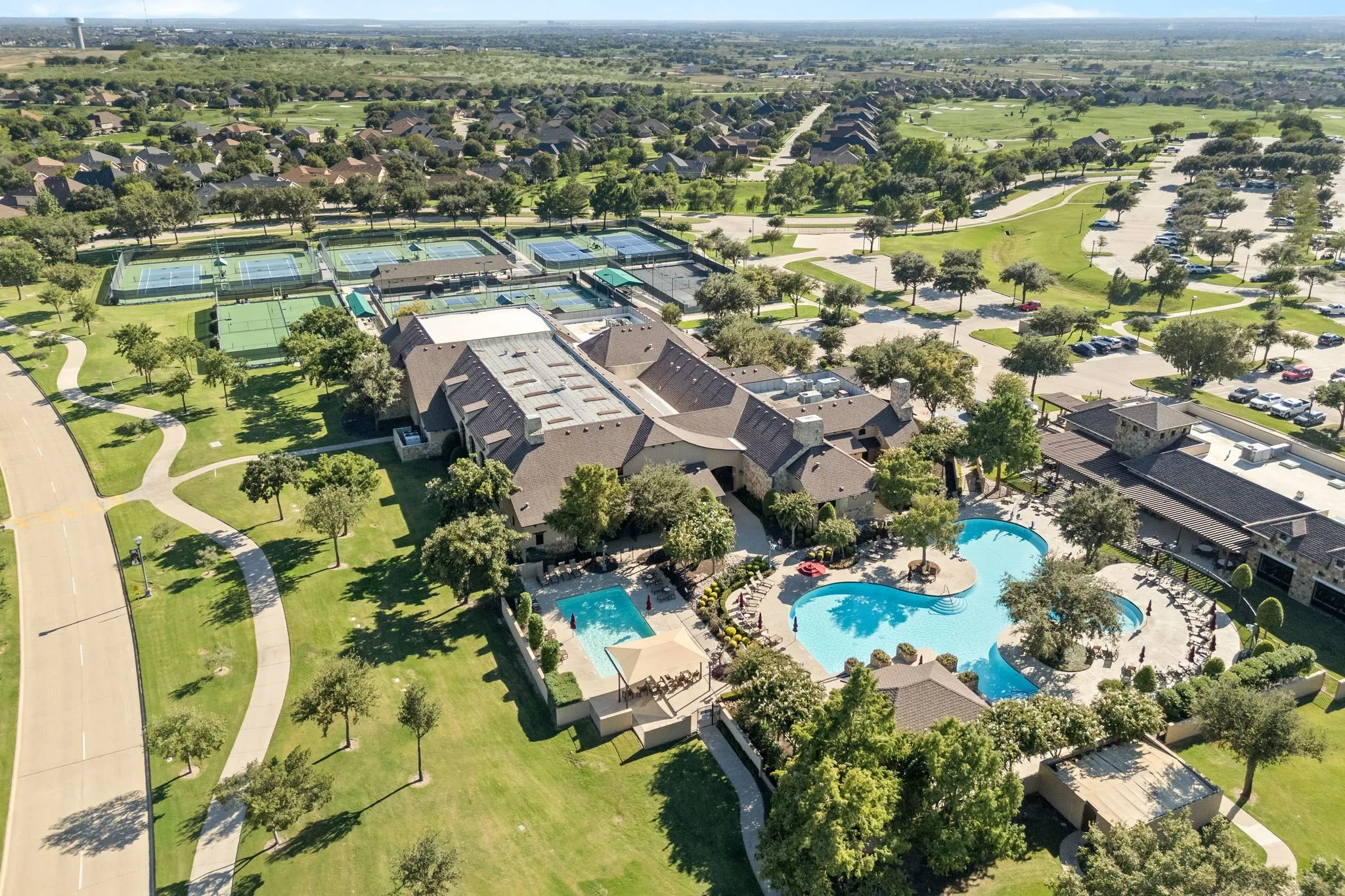 Community amenities featuring multiple tennis courts, a large clubhouse, two swimming pools, and extensive green spaces with walking paths