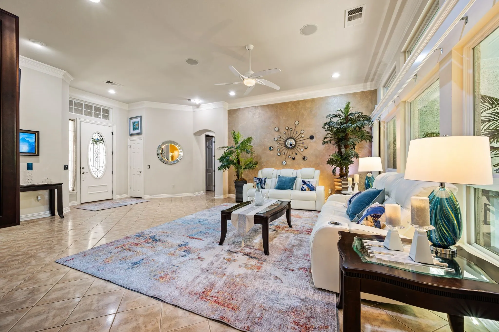 Expansive tile flooring, decorative front entry door with glass insert, high ceilings, recessed lighting, and large windows with transom details