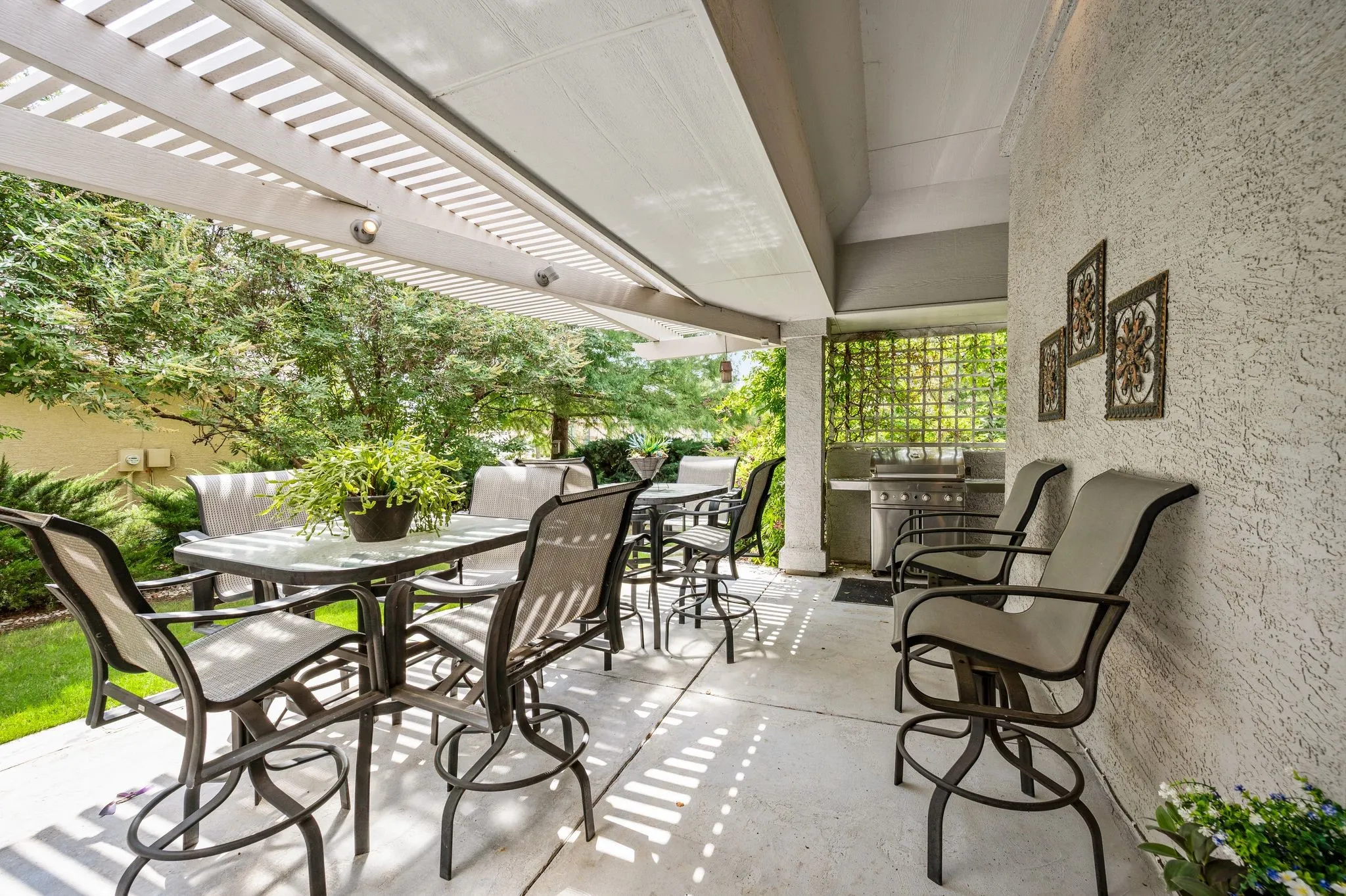 Patio with a pergola, textured exterior wall, built-in outdoor grill, and concrete flooring