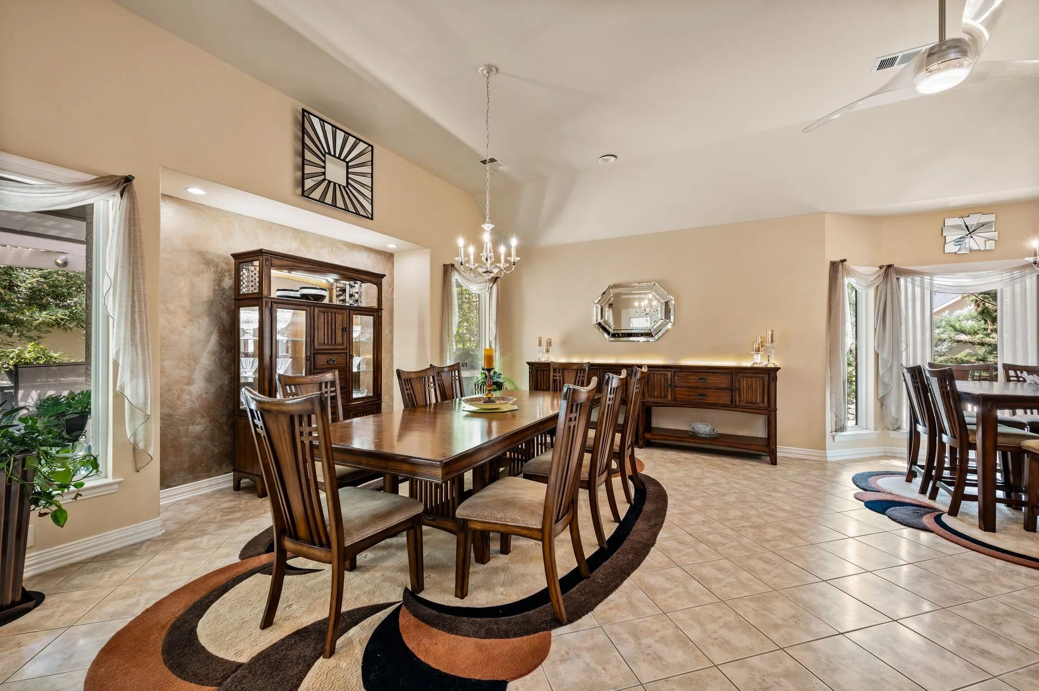 Vaulted ceilings, large windows with decorative drapery, recessed lighting, and tile flooring