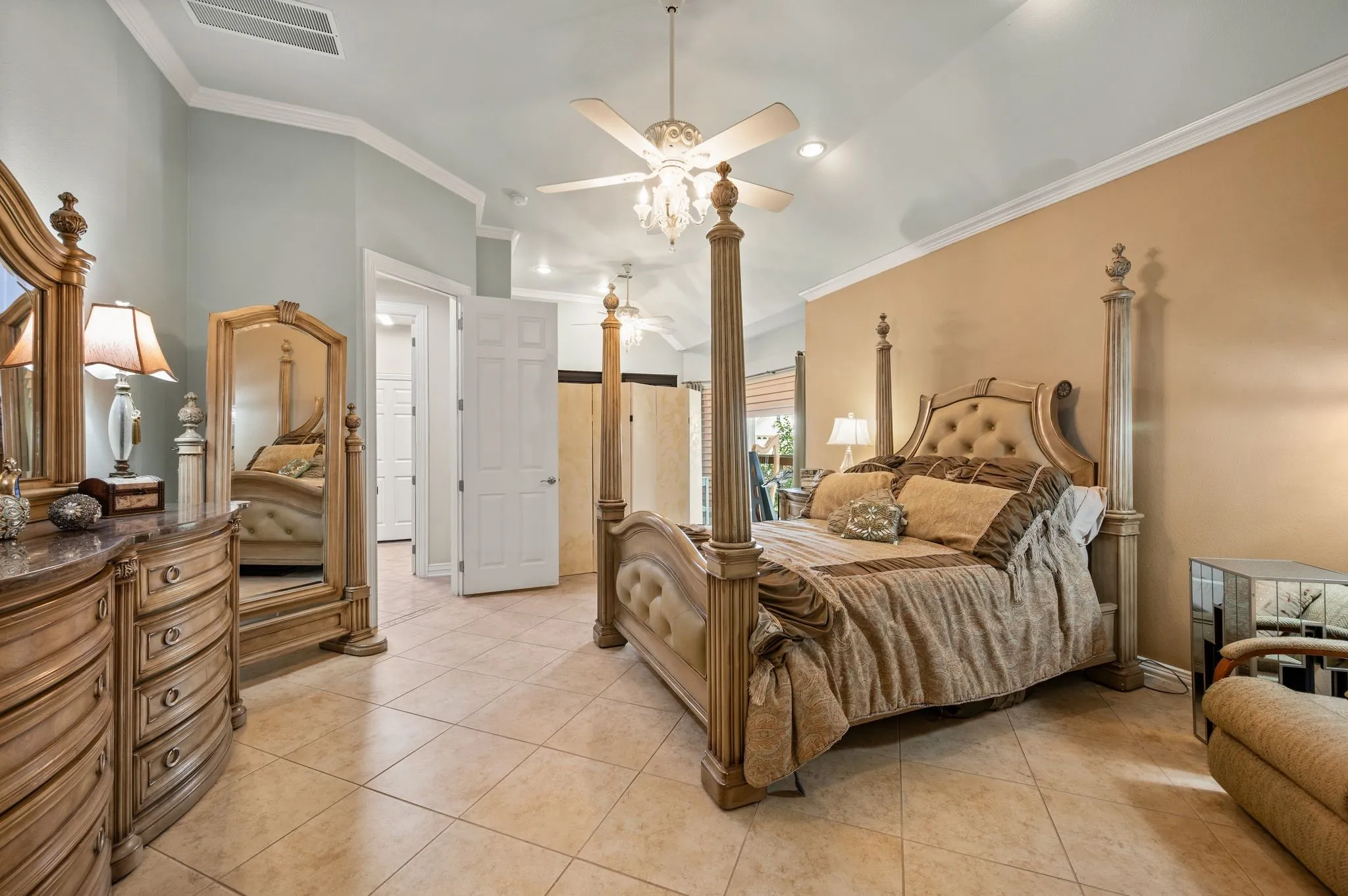 Vaulted ceiling with crown molding, ceiling fan, recessed lighting, tile flooring, and multiple doorways