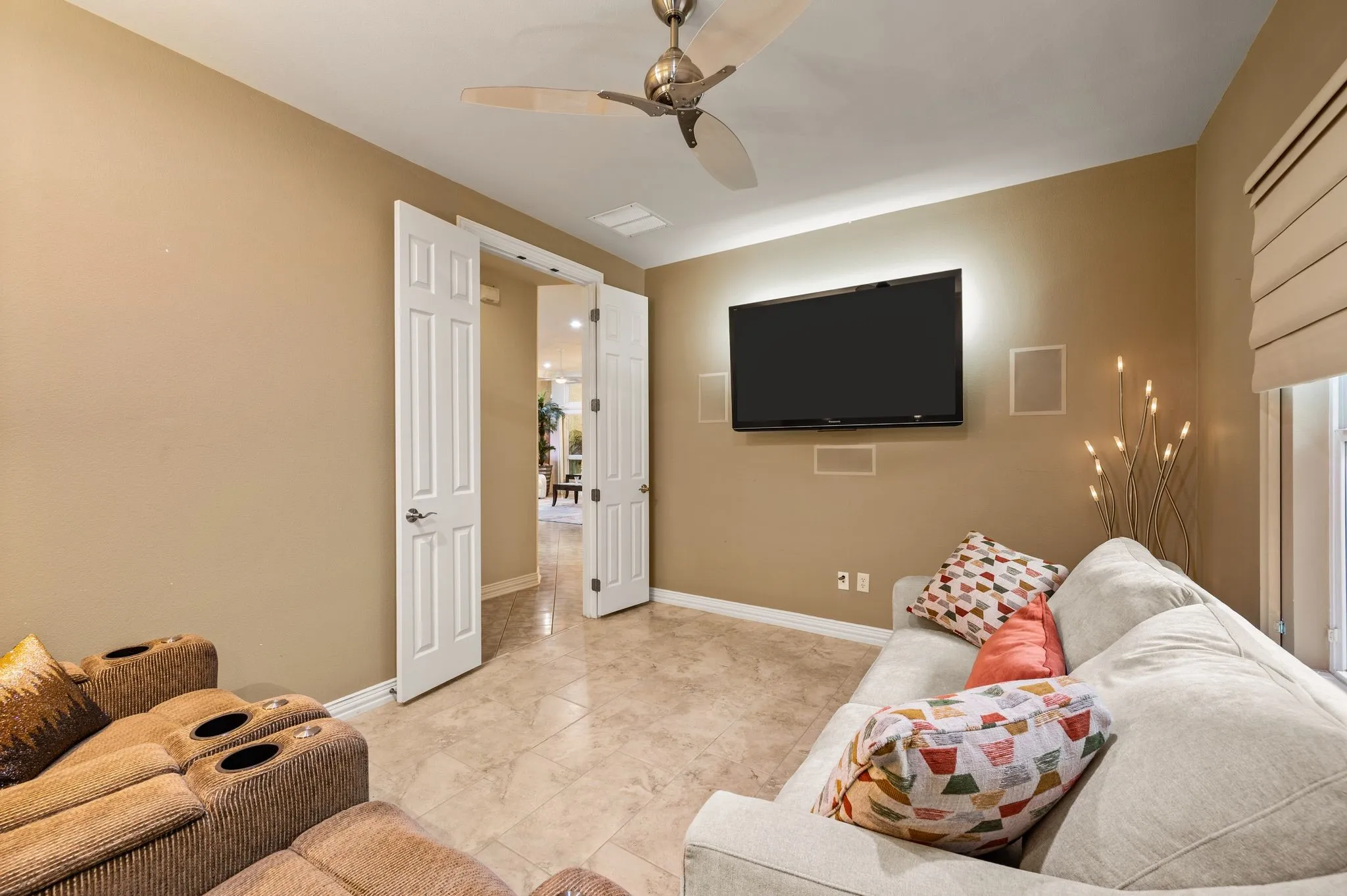 Recessed lighting, ceiling fan, tile flooring, built-in wall speakers, and a window with a Roman shade