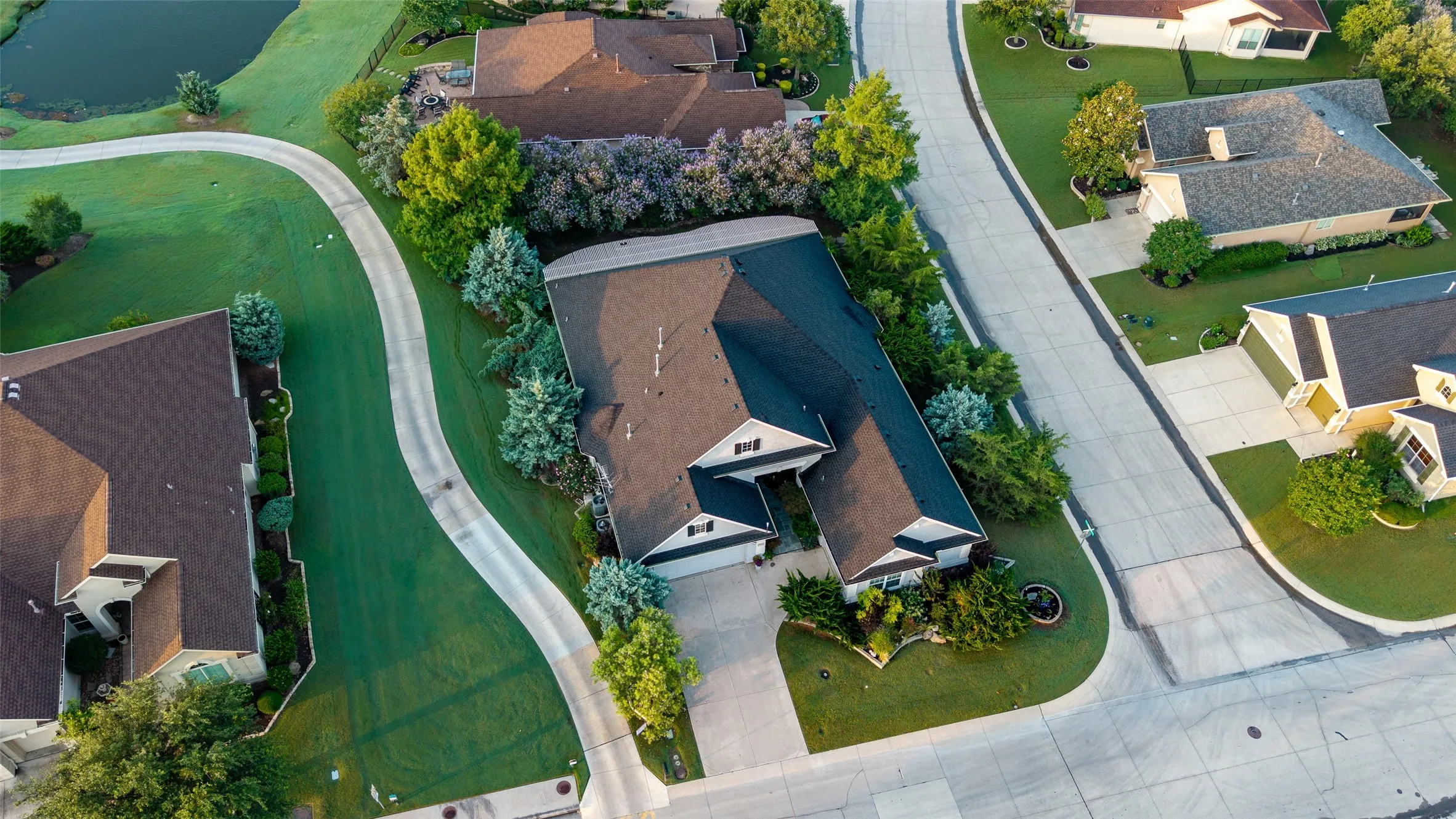 Pitched roofline residence with an attached two-car garage, concrete driveway, and established perimeter landscaping