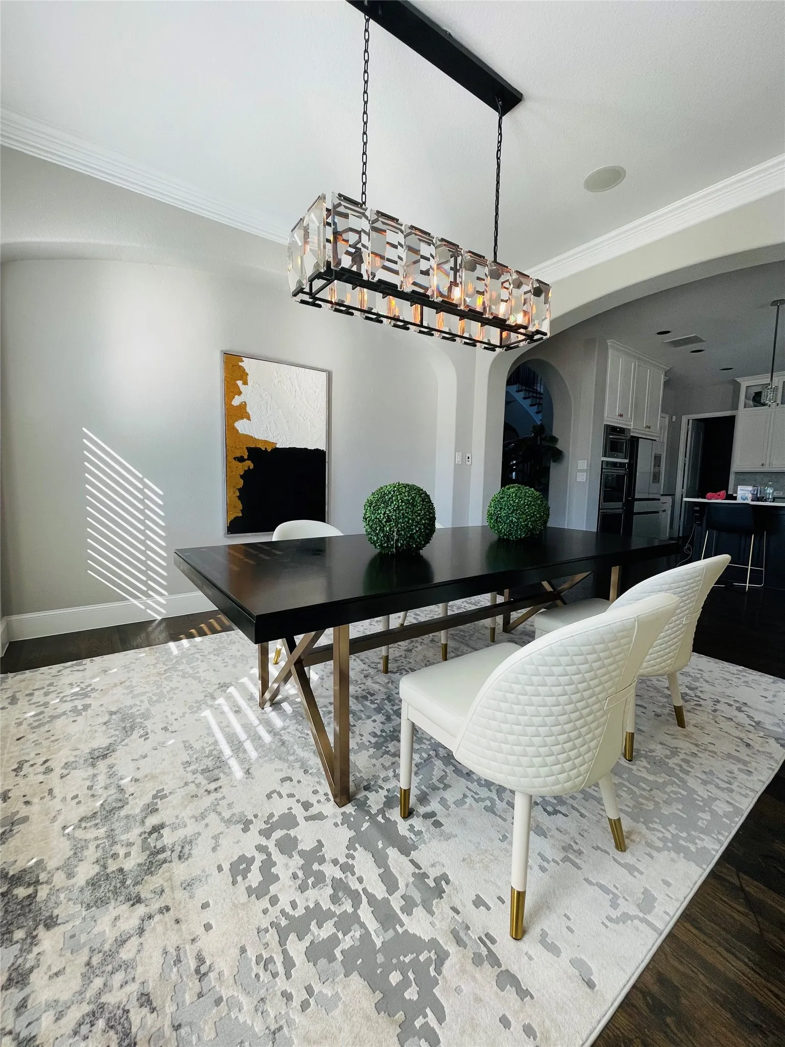 Dark wood-finish flooring with a light-toned area rug