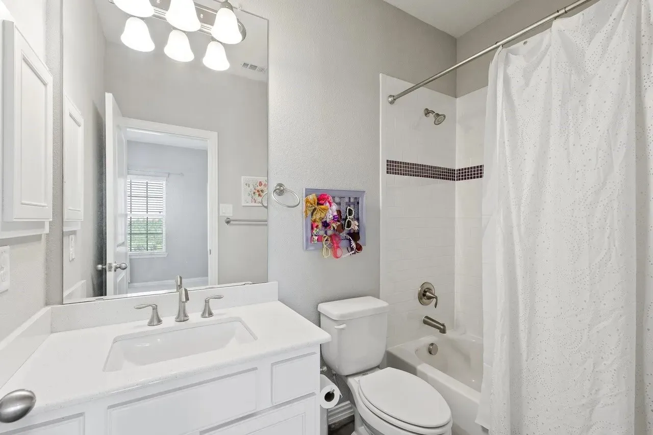 Vanity with an integrated sink, brushed nickel faucet, and a large mirror