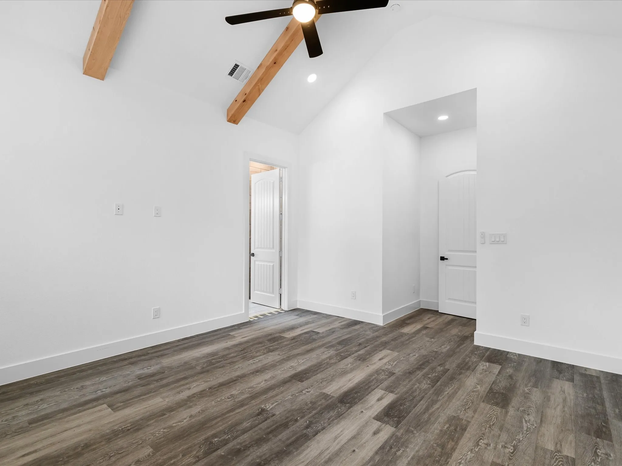 Vaulted ceiling with exposed wood beams, wood-finish flooring, recessed lighting, and a ceiling fan