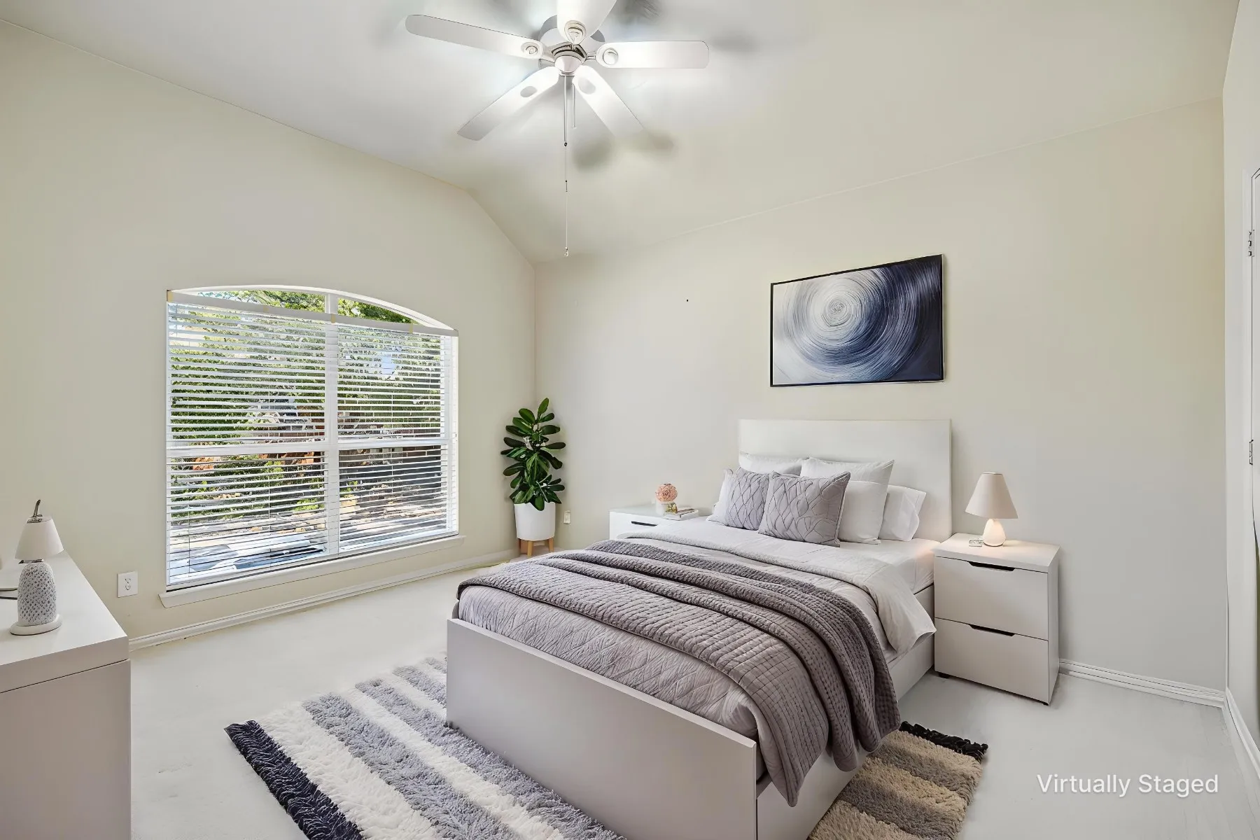 Arched window with blinds, vaulted ceiling, and a ceiling fan