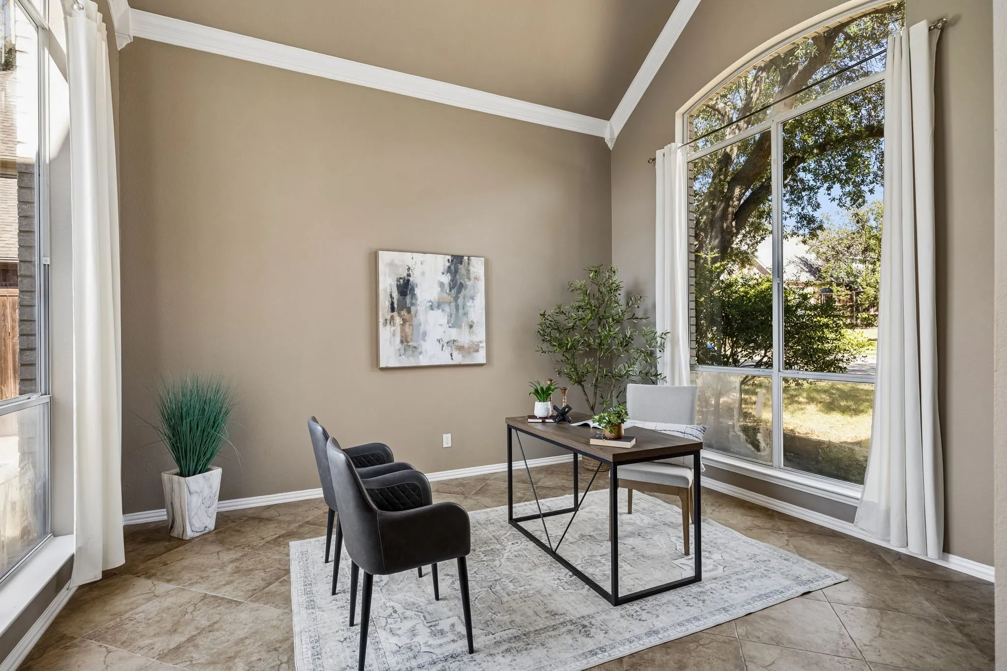 Vaulted ceiling, arched picture window, large windows, crown molding, and tiled flooring