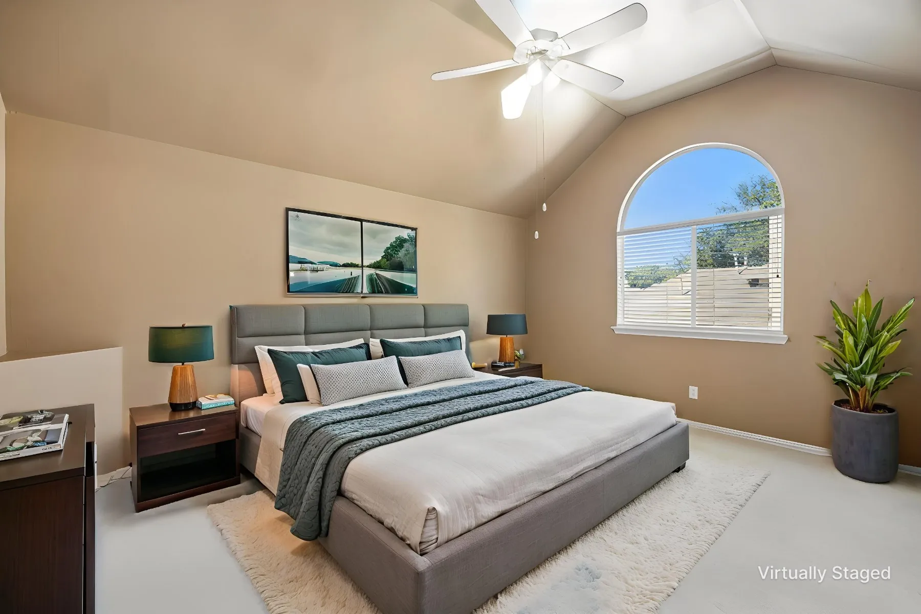 Vaulted ceiling with an installed ceiling fan, an arched window, and neutral wall tones