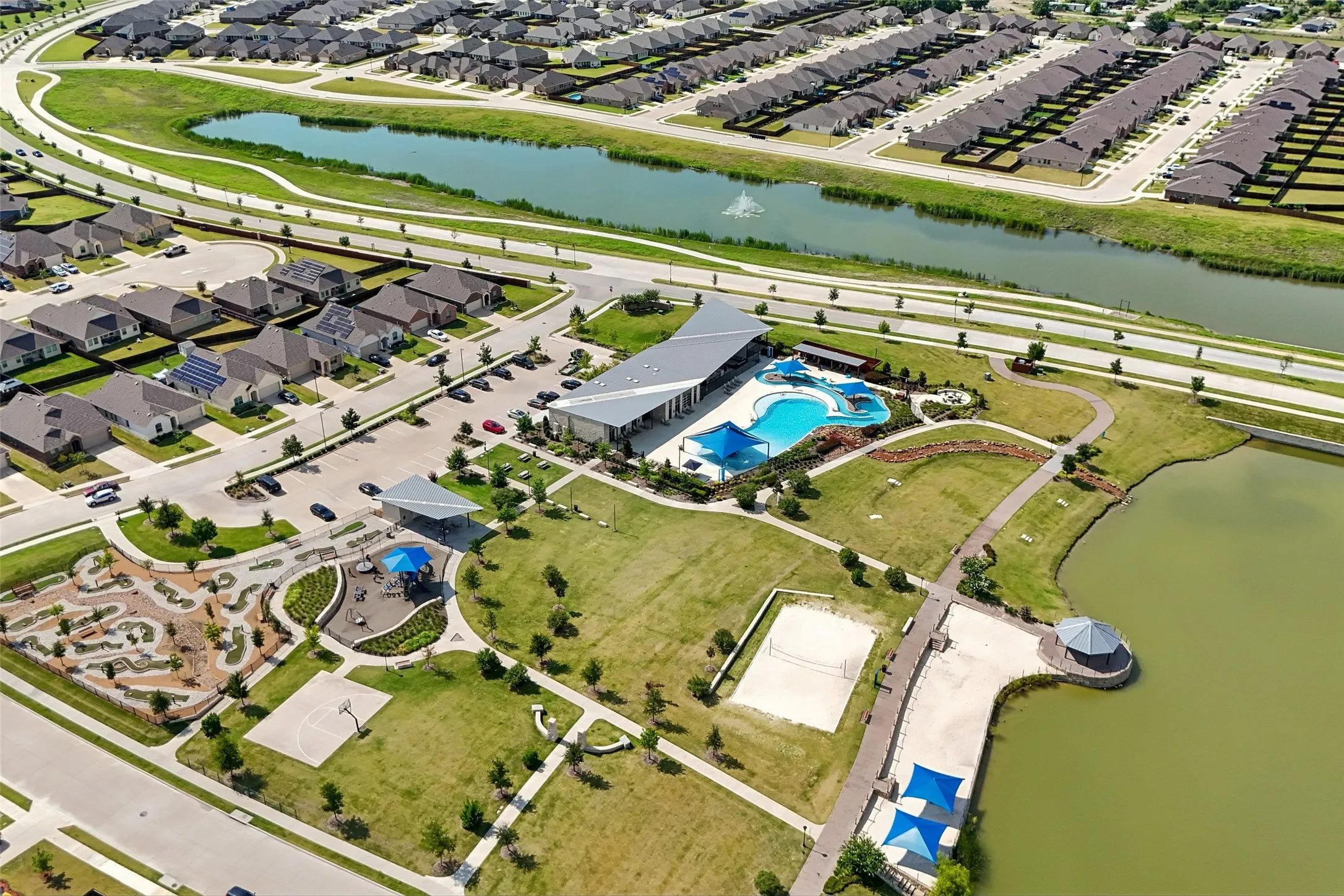 Community pool with shaded seating, volleyball court, basketball court, mini-golf, and direct water access