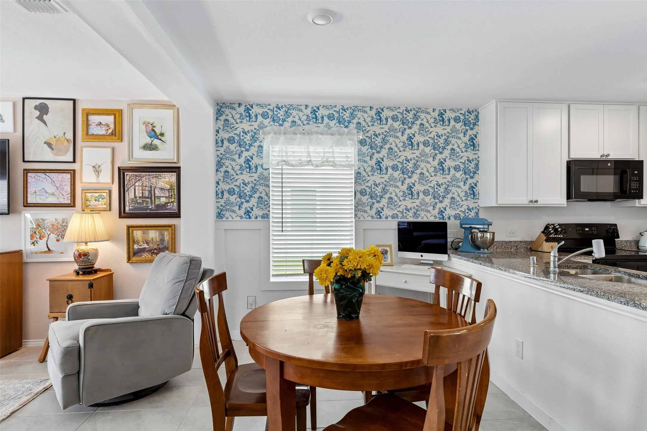 White cabinetry with matte black hardware, granite countertops, and a built-in microwave
