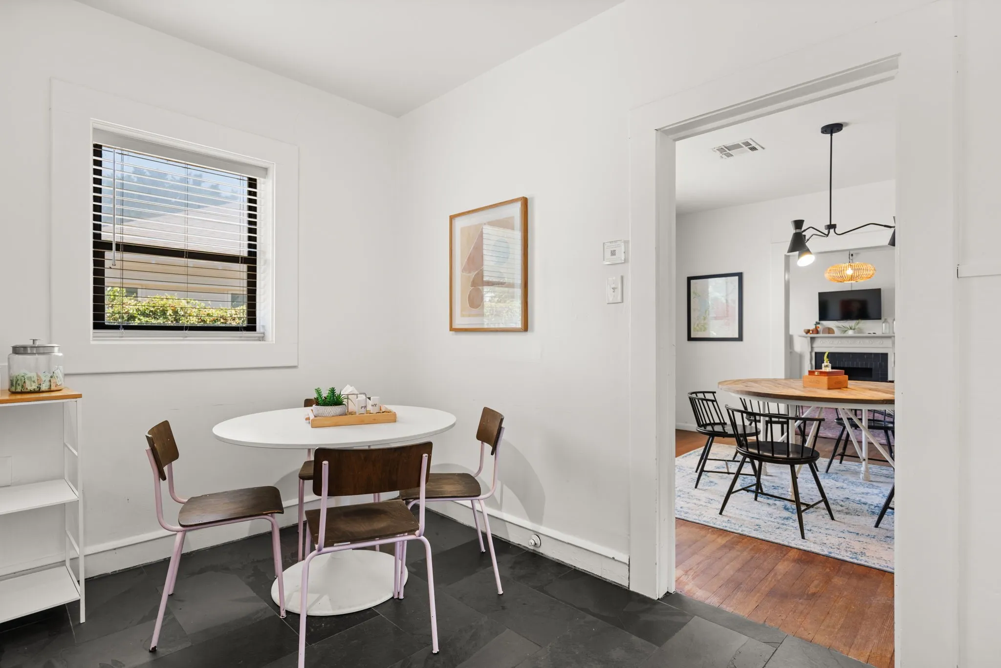 Dark slate tile flooring, white painted walls, and a single window with blinds