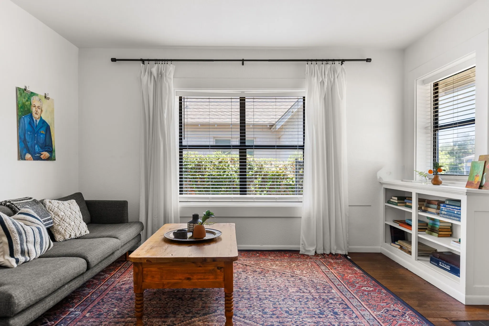 Built-in shelving, wood-finish flooring, and multiple windows with blinds