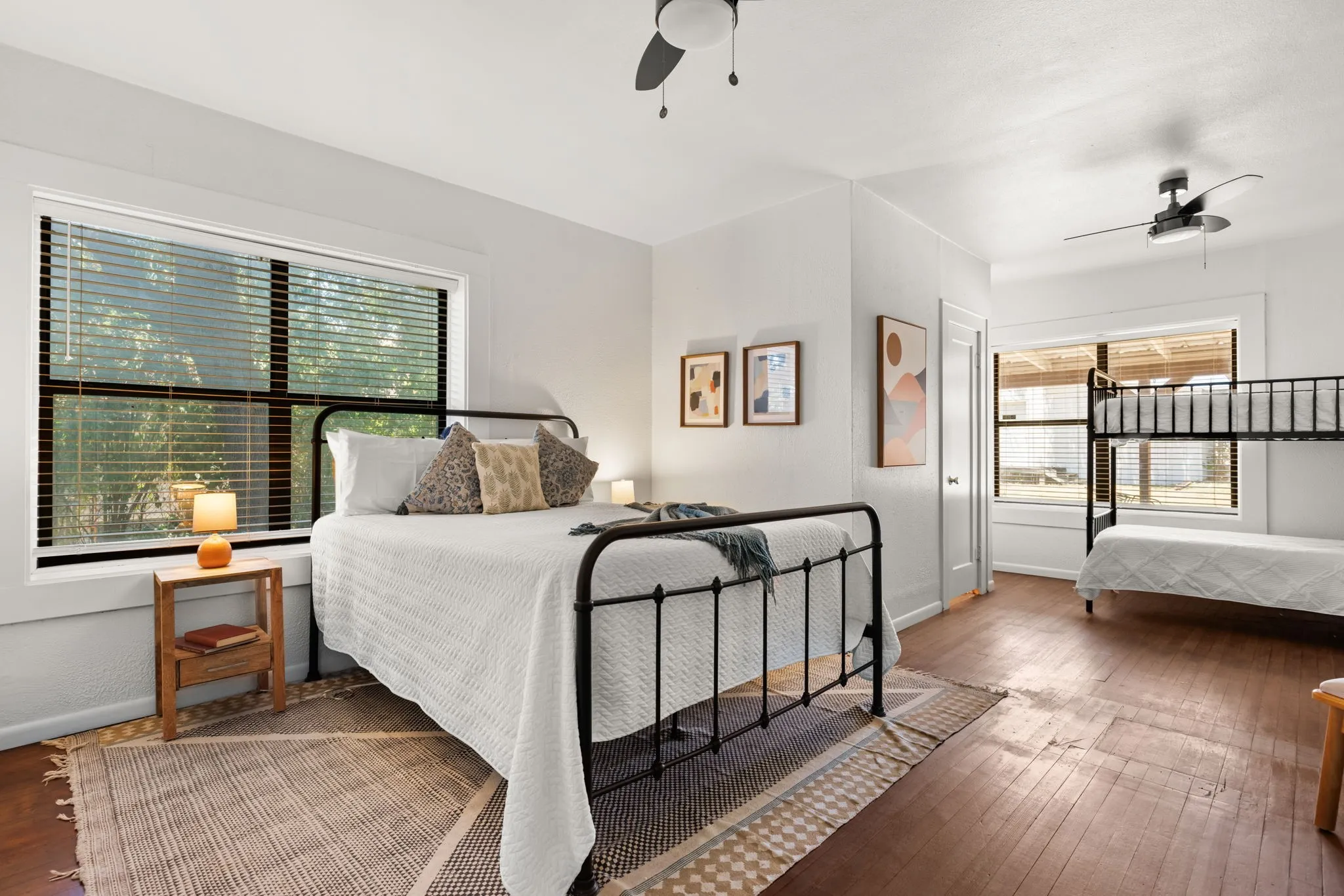 Hardwood flooring, white walls, and dual ceiling fans