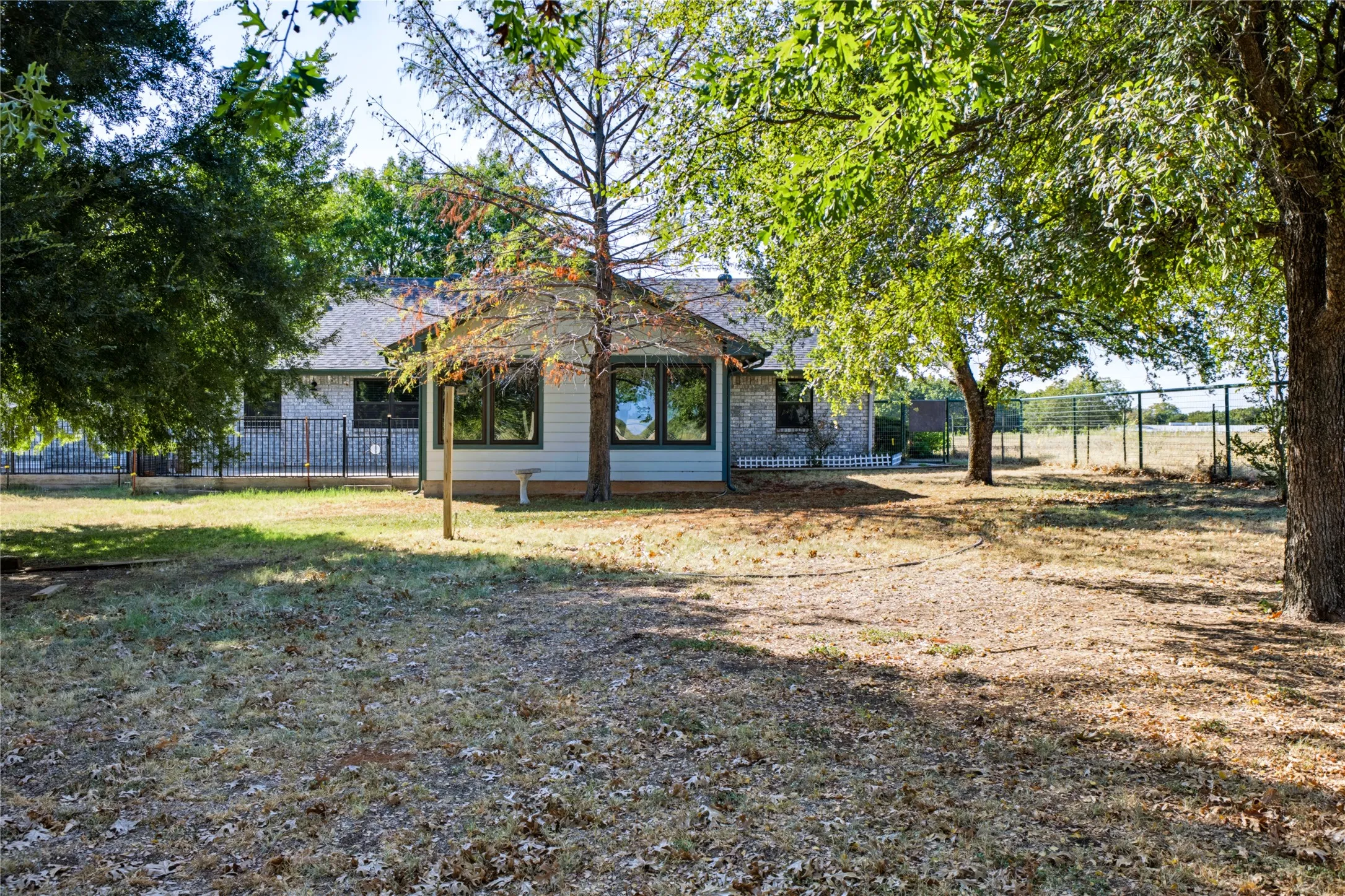 Back of home in a shaded backyard.