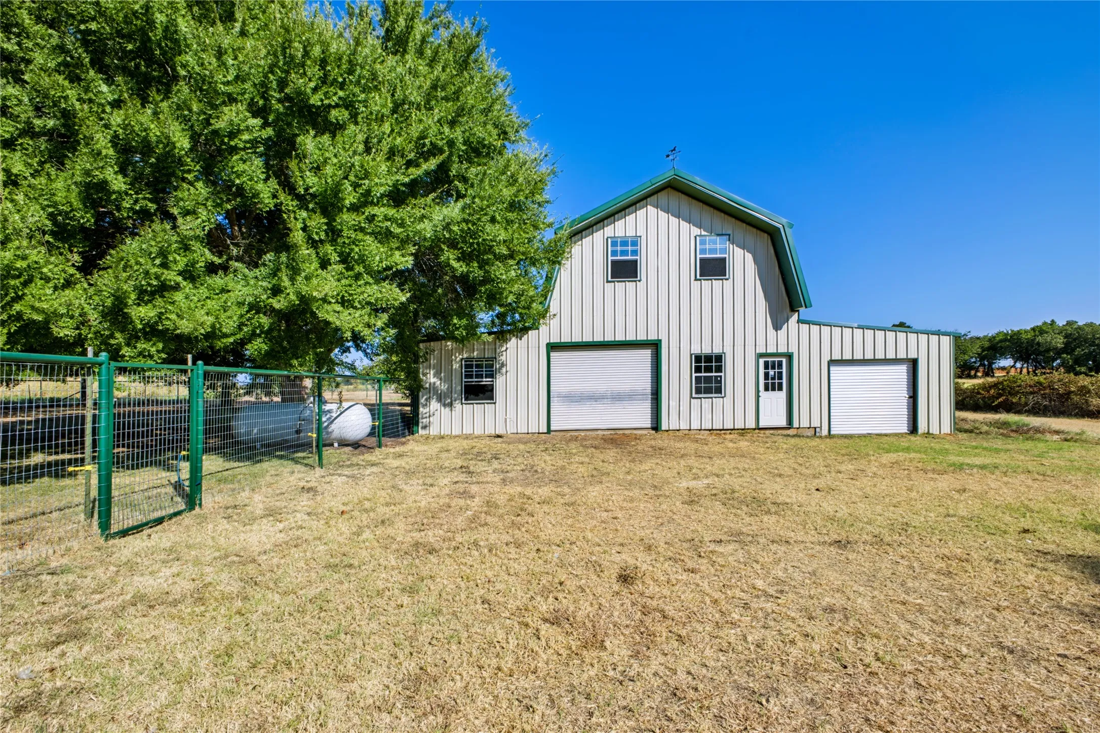 Large barn with 2 roll-up doors, 3 sections interior, and an upstairs area!