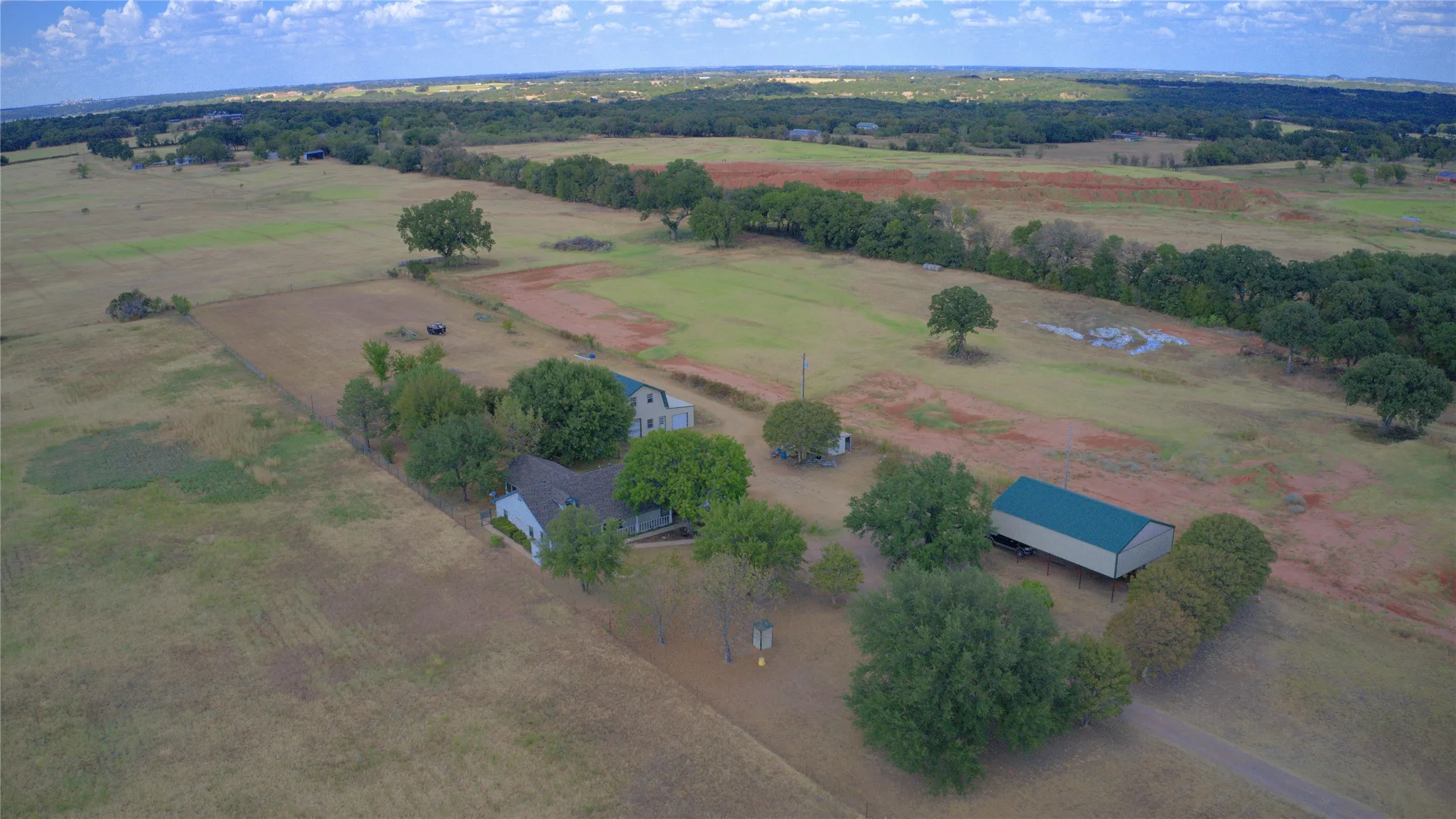 Aerial view shows home, barn and RV carport.