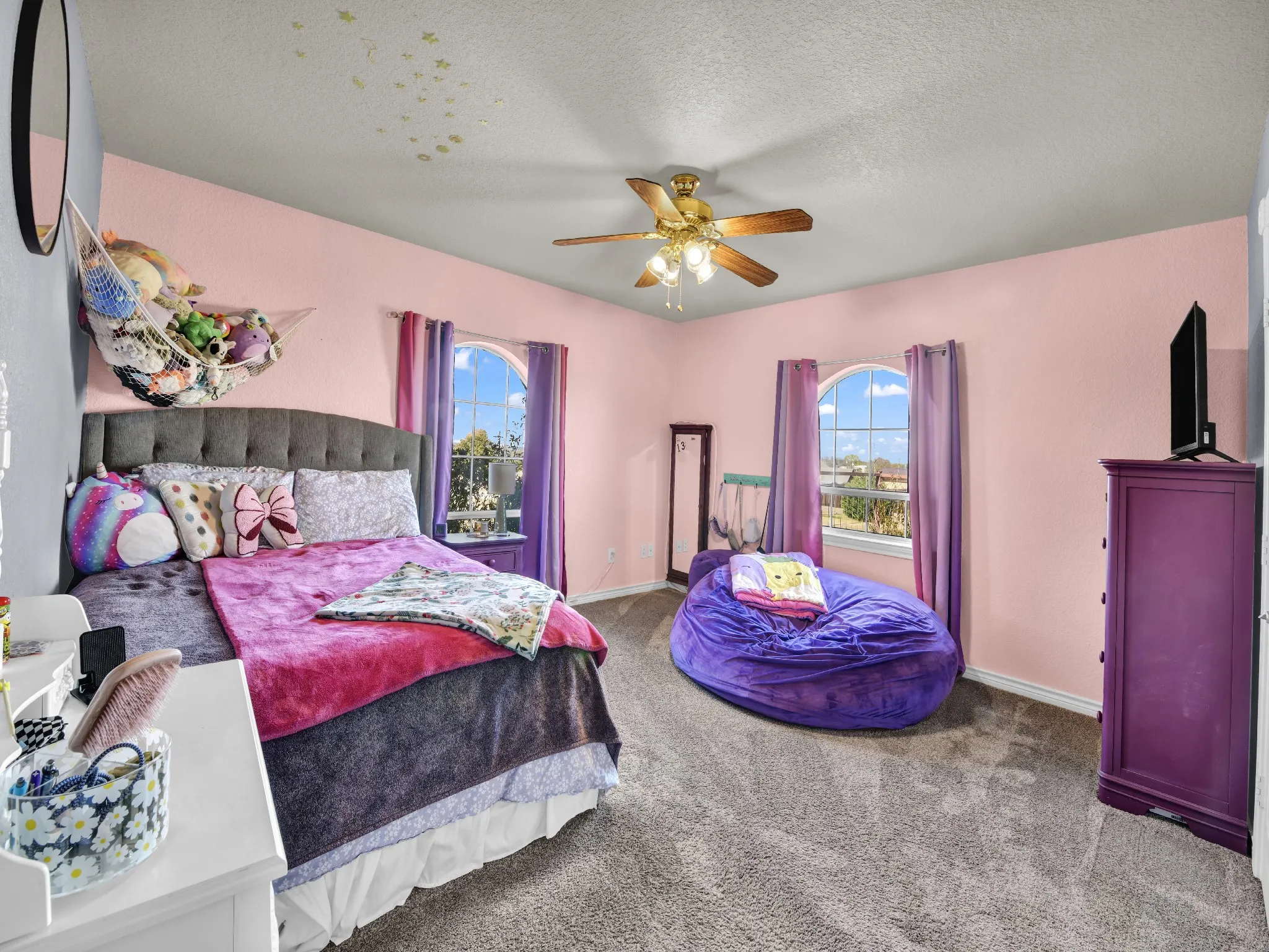Carpeted flooring, vaulted ceiling, arched window, and a ceiling fan with integrated lighting