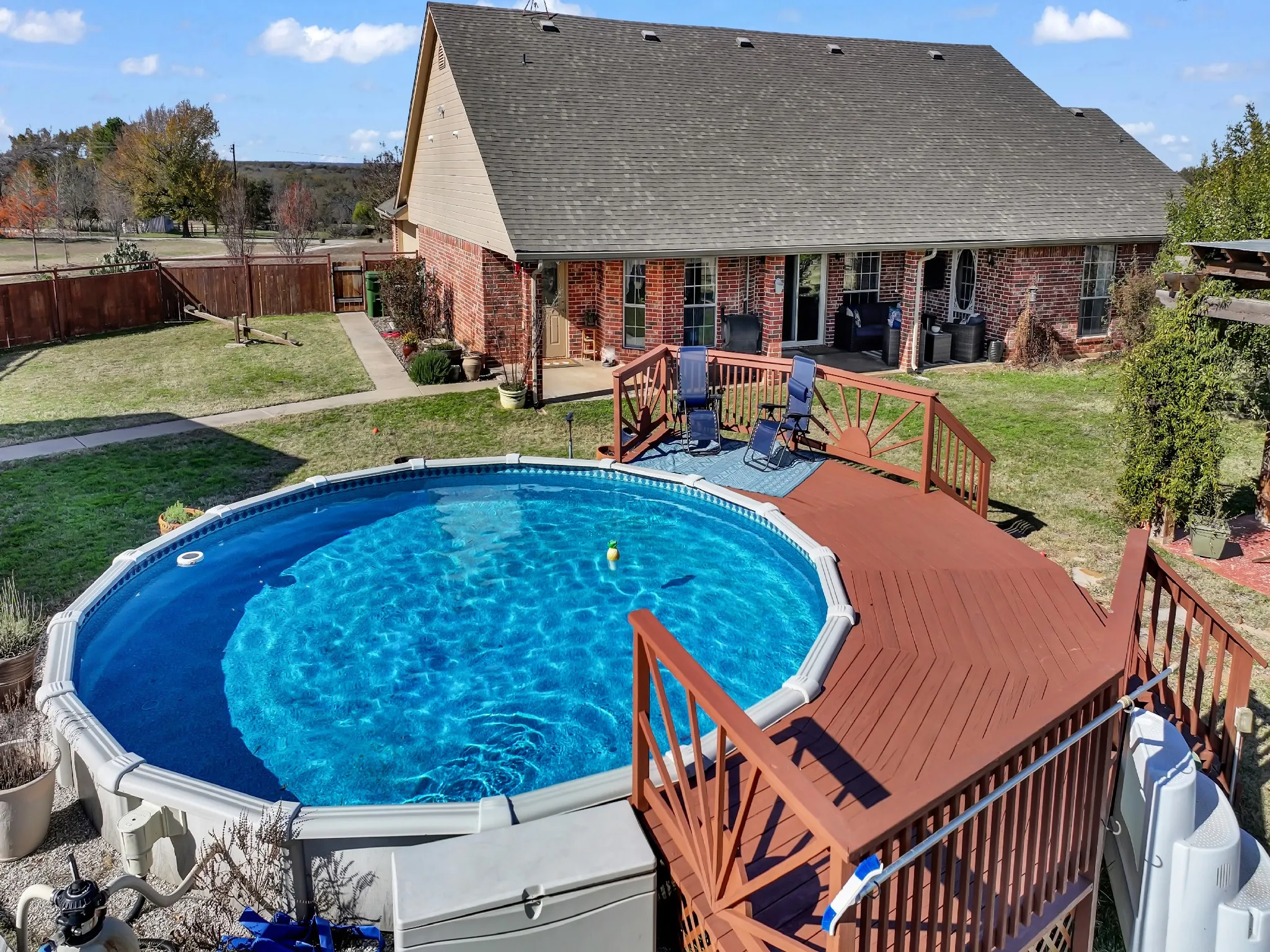 Above-ground pool with surrounding wood-finish deck