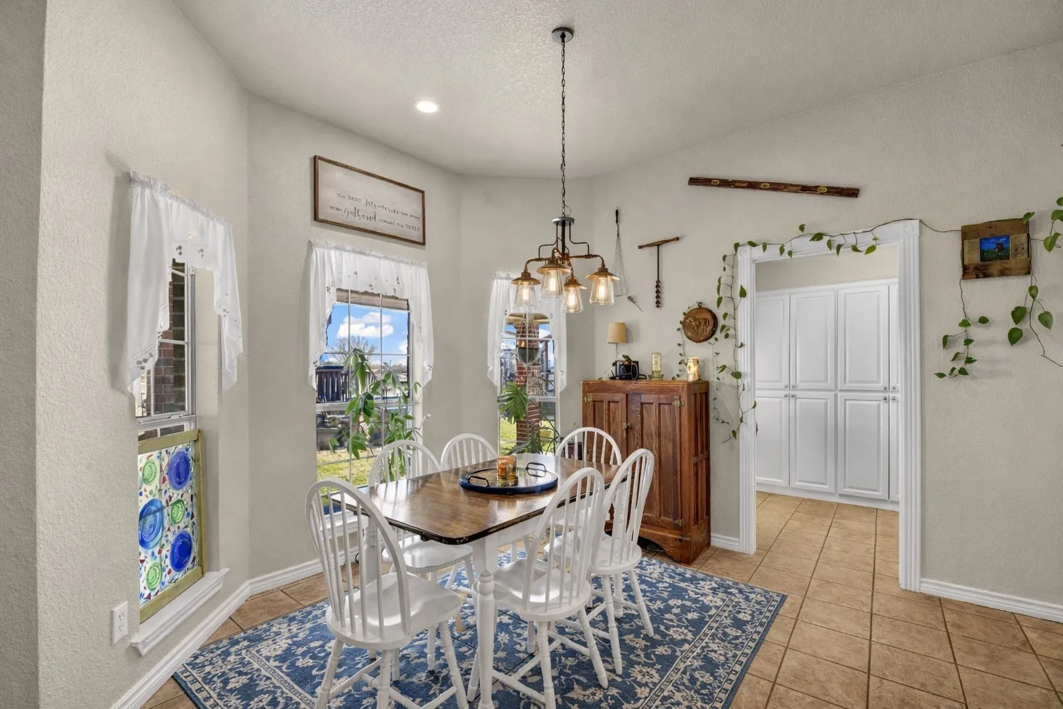 Recessed lighting, industrial-style chandelier, tile flooring, built-in cabinetry, and multiple windows