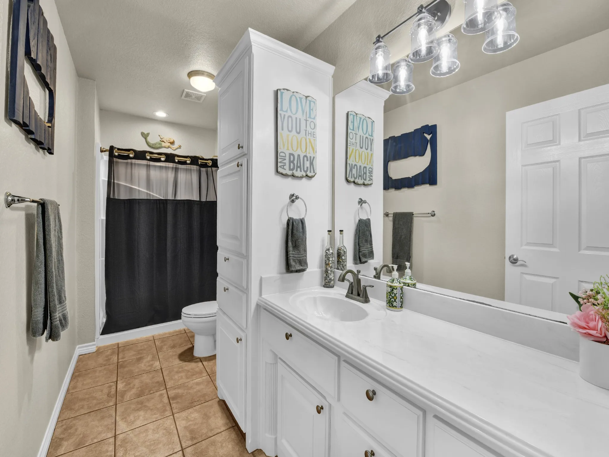 Vanity with a single basin, white countertop, and integrated storage cabinetry