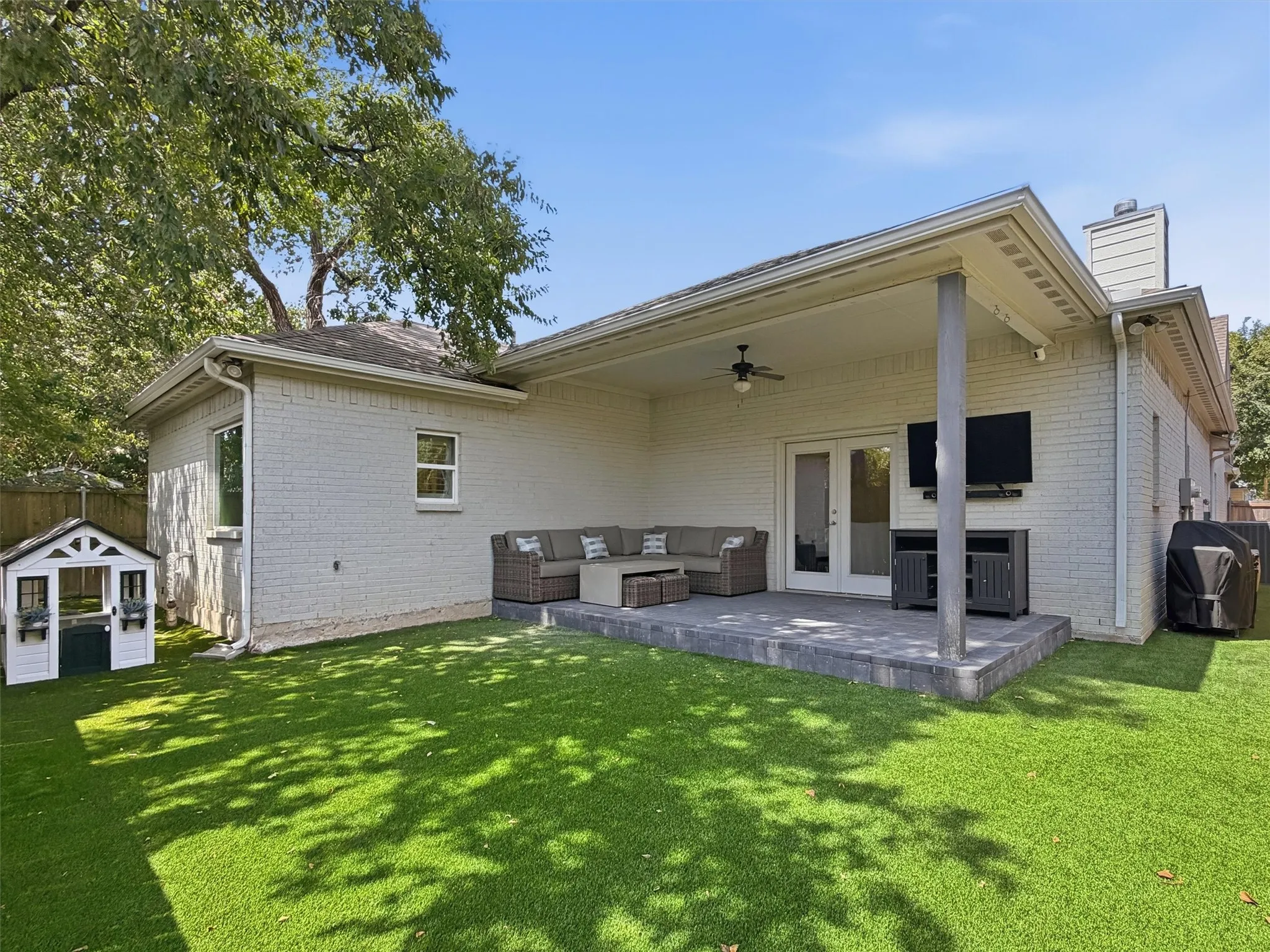 This low-maintenance private backyard features vibrant green turf (2023) and an outdoor mosquito system (2025) for year-round comfort. A covered patio complete with a ceiling fan, TV mount, and outdoor media setup creates the ultimate venue for outdoor entertainment.