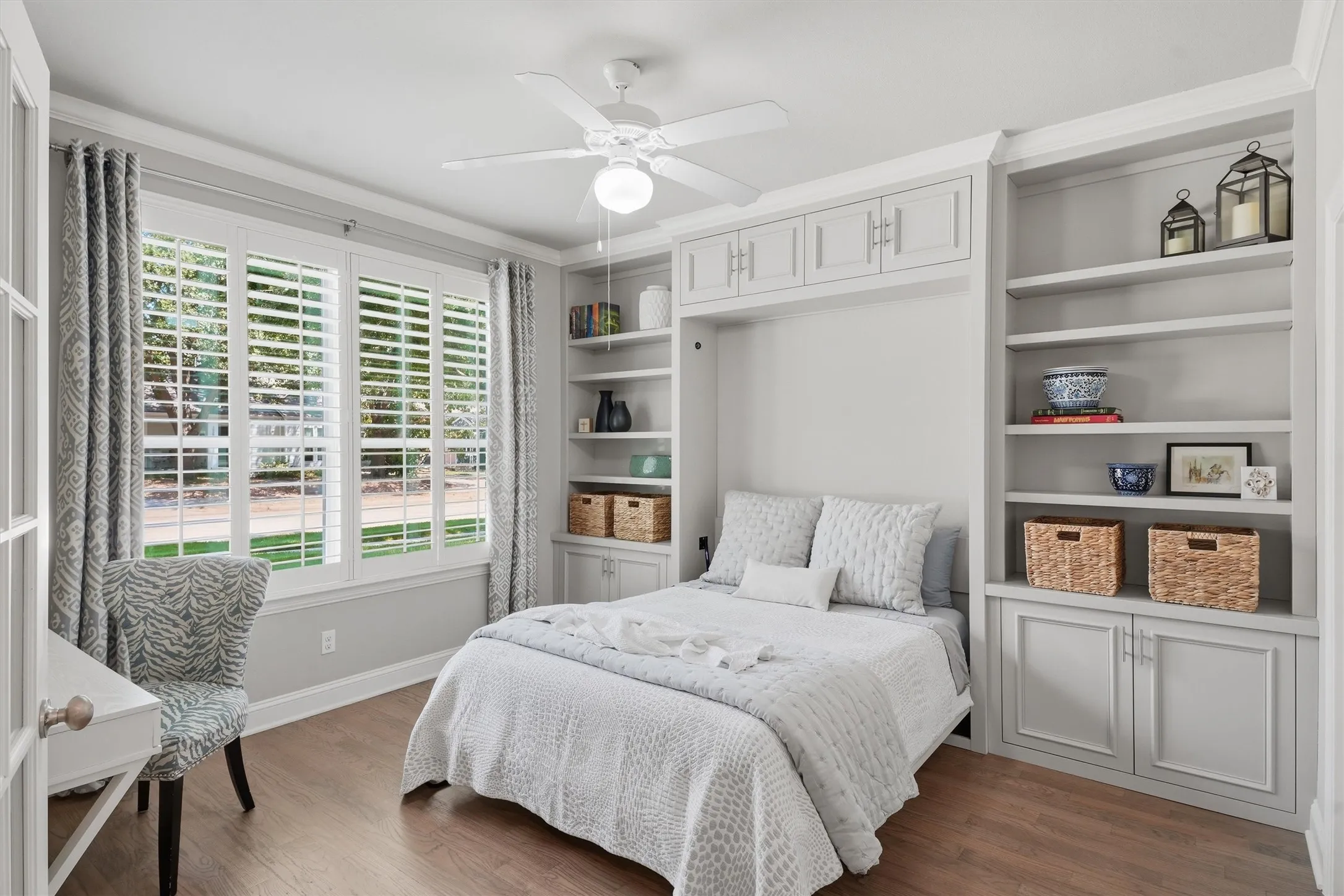 This flexible multi-use room features built-in custom shelving, plantation shutters, and glass French-door entryways. The built-in Murphy bed easily tucks away (2025 upgrade), seamlessly transforming the space from a guest bedroom into a private home office or den.